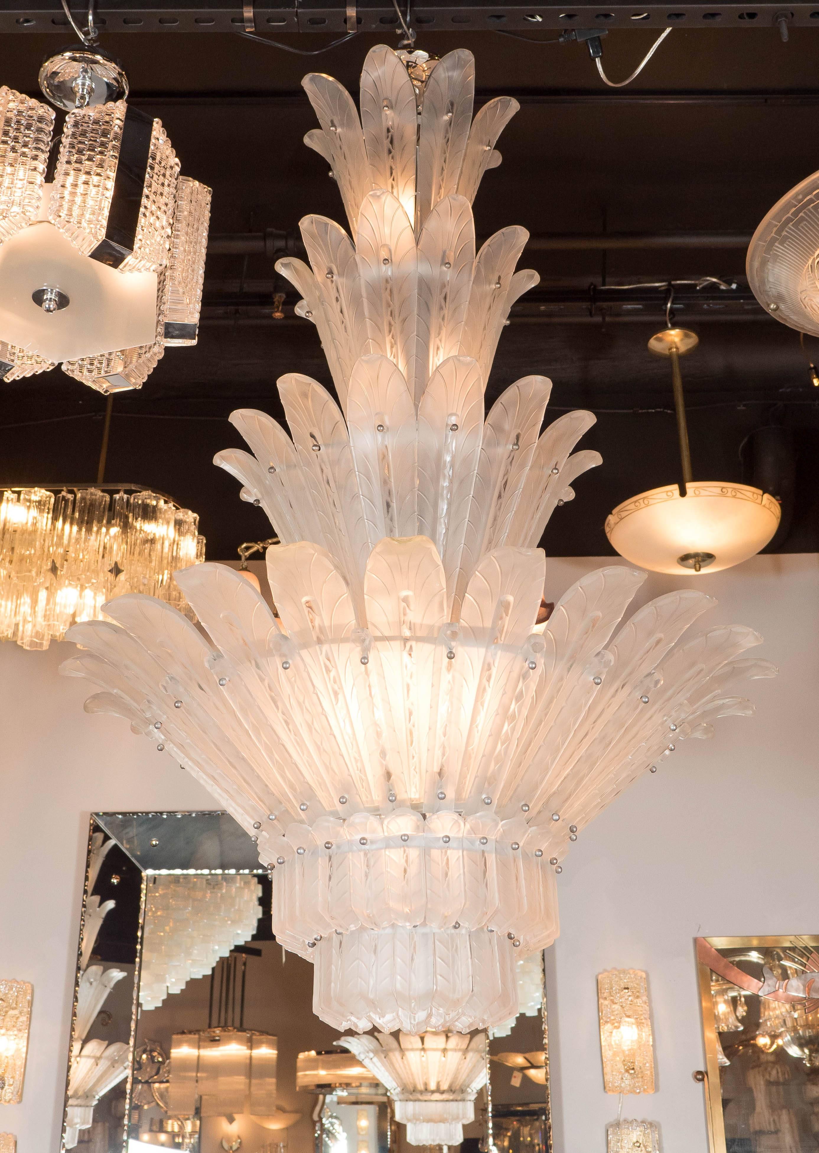 A spectacular six-tiered plume chandelier by Sabino. Its base features two layers of  chevron-etched pattern petals, and the entire fixture is comprised of frosted and clear molded glass, which lends to a wonderful glowing quality even when unlit.