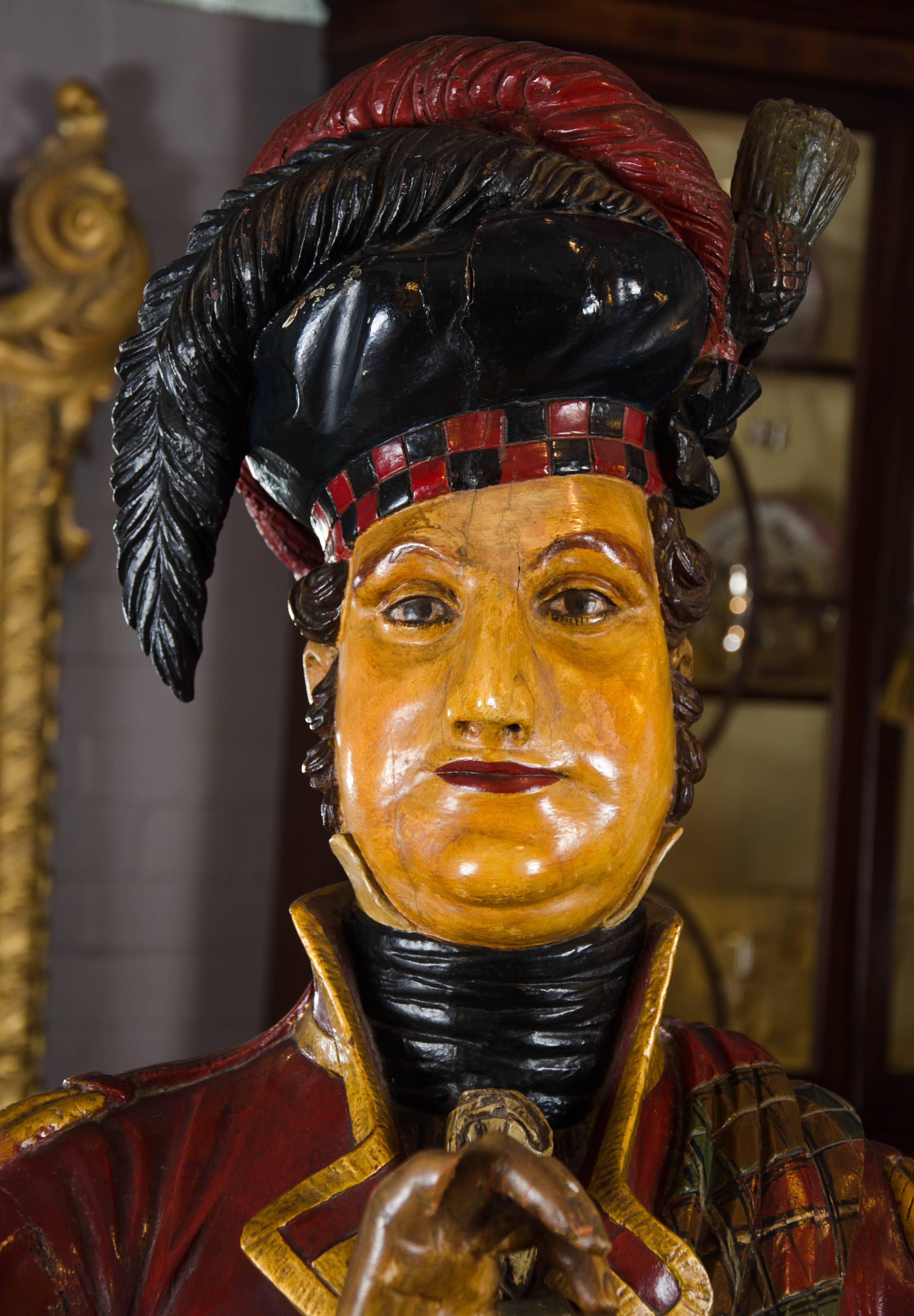 This rare life-size carved and polychrome painted tobacconist's figure is in the form of a Scottish Highlander taking snuff.

The original of this particular Highland model reputedly stood outside a tobacconist in Edinburgh, circa 1720 to signify