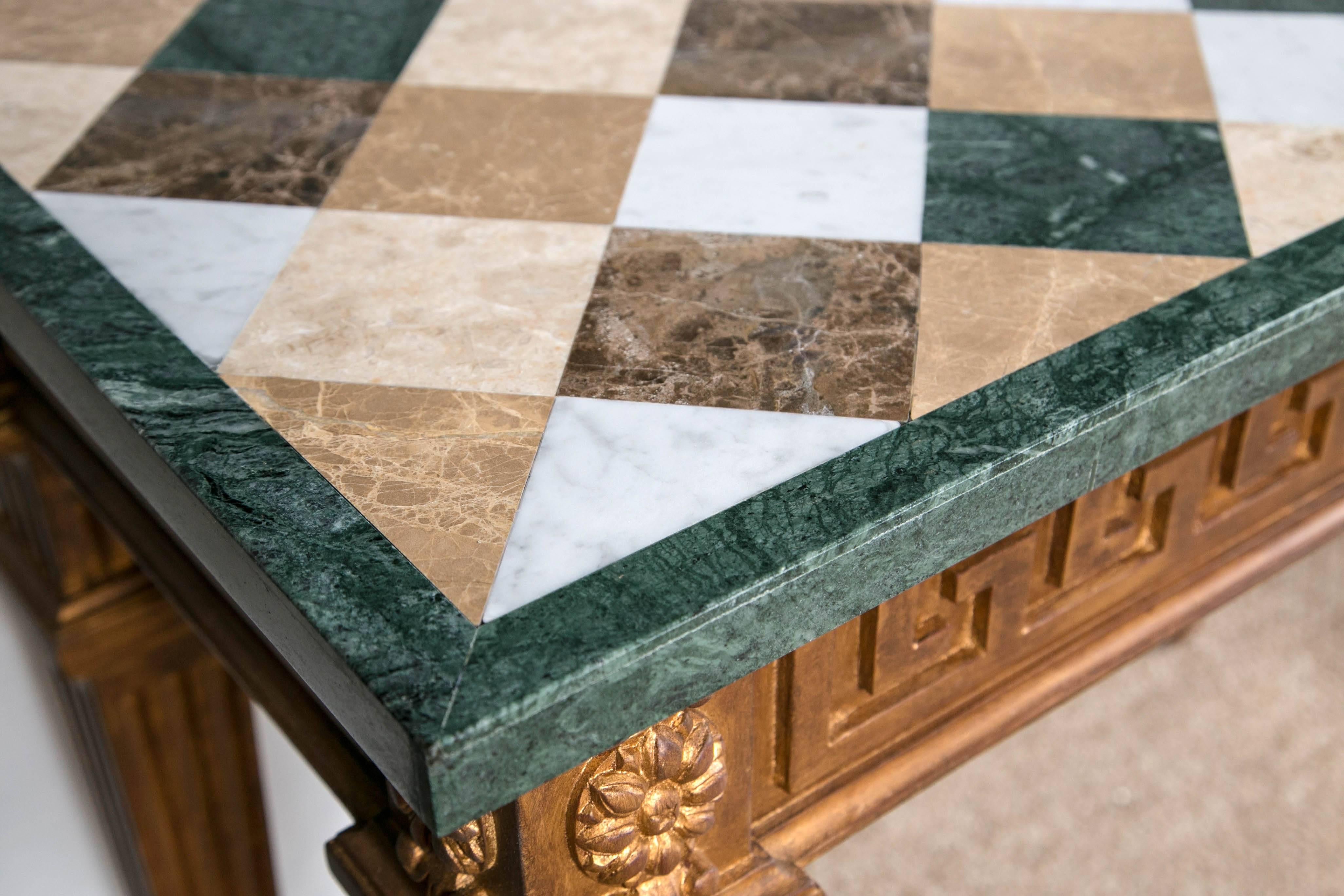 A pair of neoclassical style marble-top Greek key design console tables. This fine pair of marble veneer checkerboard top console are all handmade having a base of Greek key and urn design sitting on tapering legs. 

Measures: 43 L x 23 W x 34