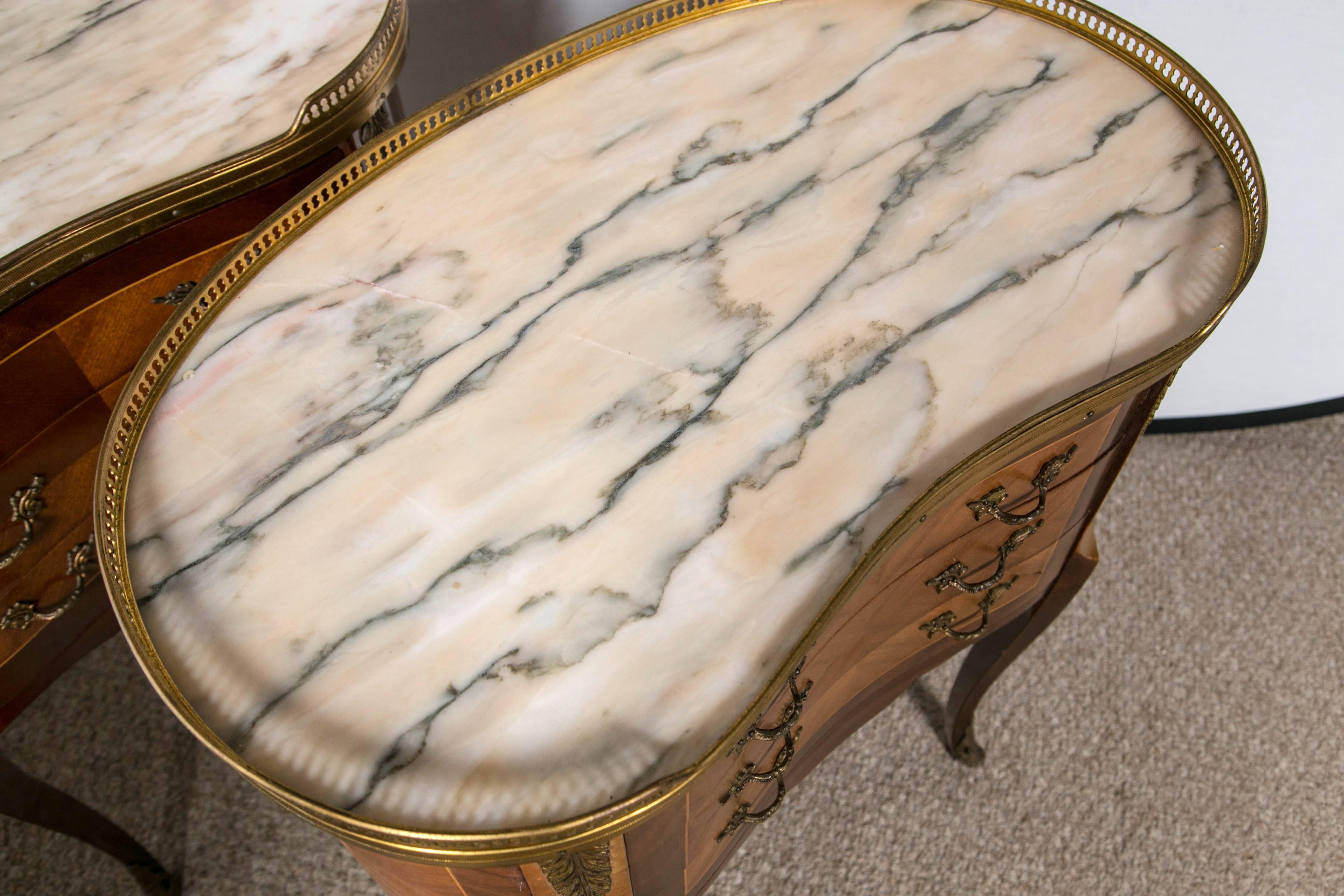 Pair of Louis XV style marble kidney shaped top stands. A beautiful pair of kidney shaped galleried marble top stands. Each having walnut and satinwood cases with bronze mounts and concaved fronts. The thing curved legs supporting three center