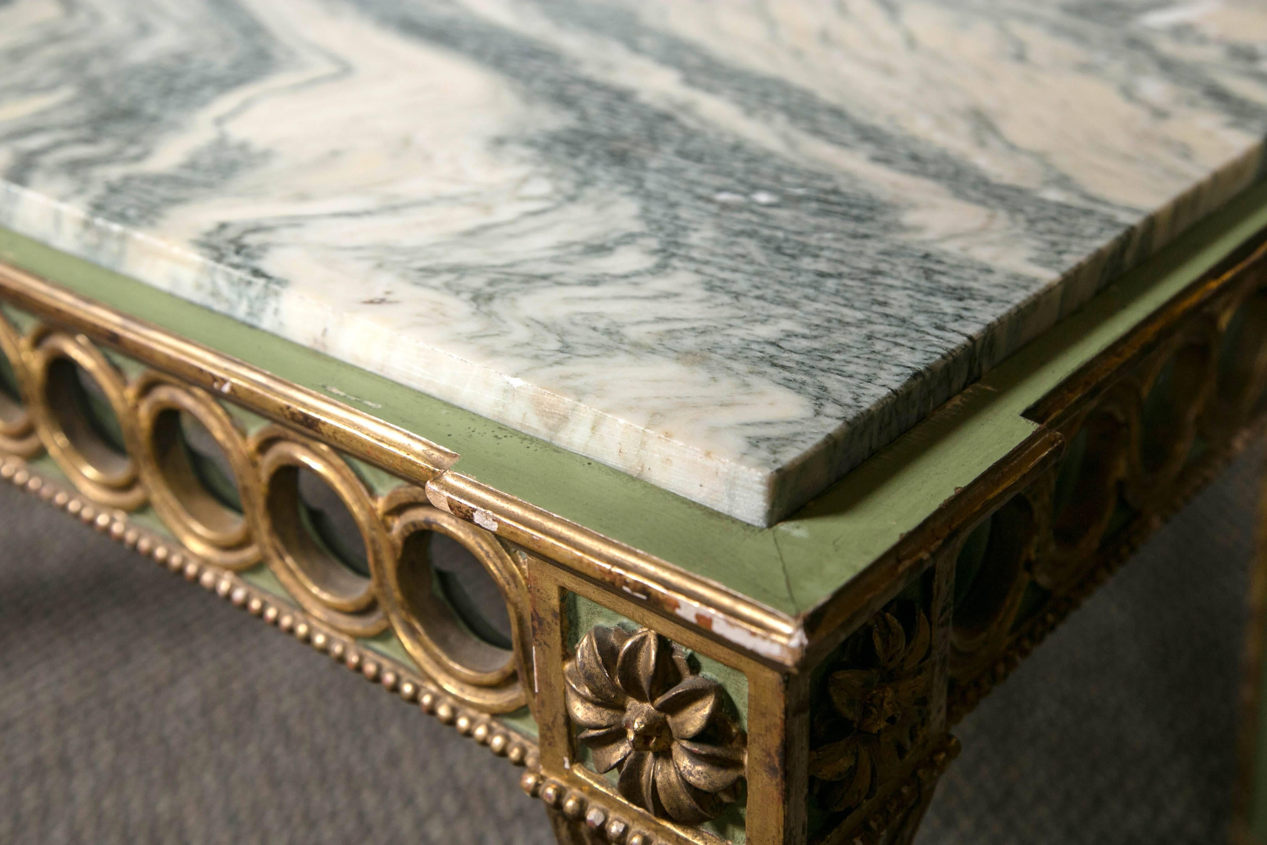 Hollywood Regency paint decorated marble-top coffee table by Jansen. This beautiful French Sage painted coffee table offsets the gilt gold decorations highlighted in the overall design of this wonderfully carved handcrafted table. The incised legs