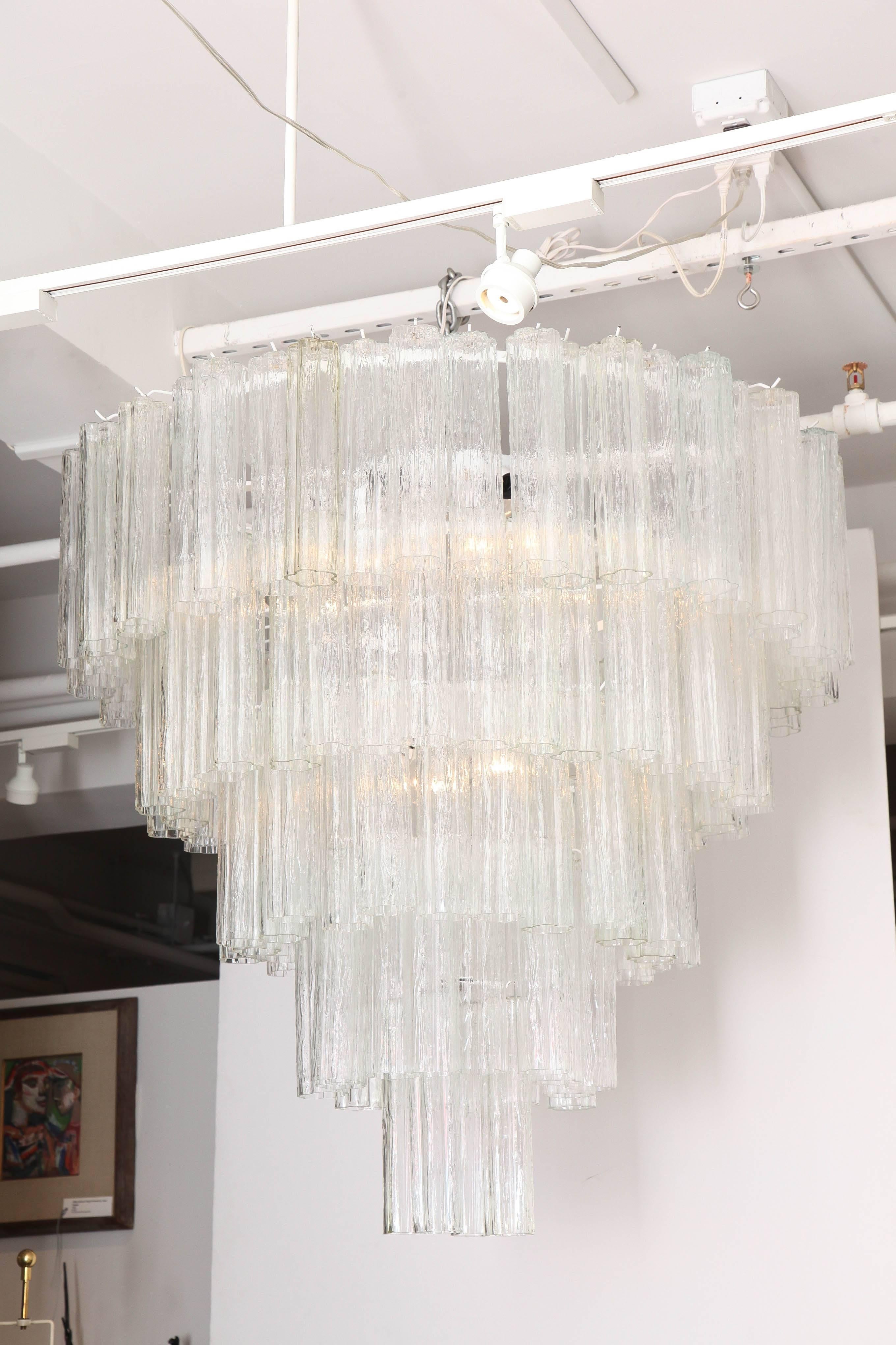Monumental five-tier Tronchi tube chandelier by Venini and sold through Camer Glass. Glass tubes have a slight ice textured effect and are suspended from a white enamel frame. Polished nickel chain and canopy included. 