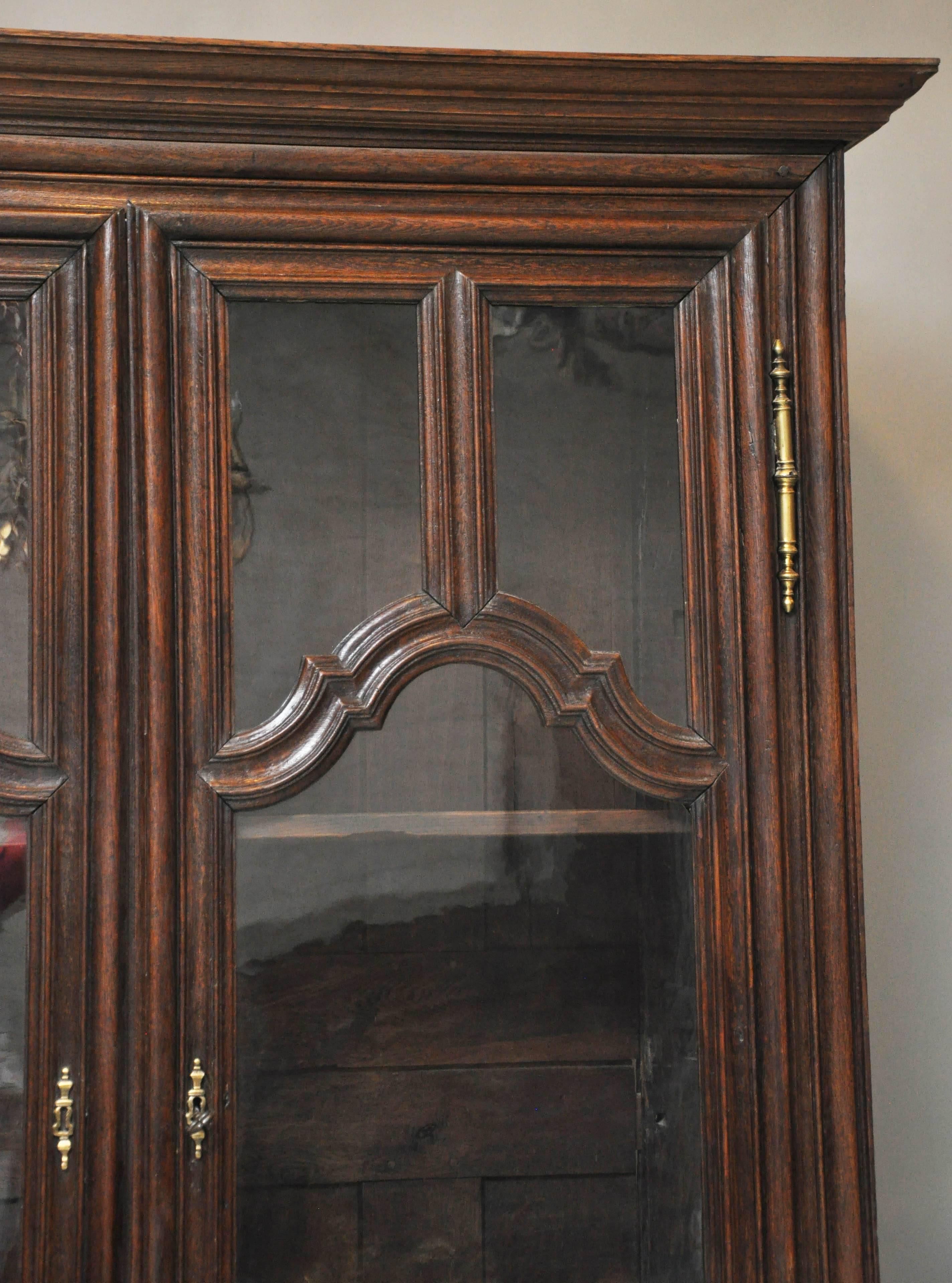 French Louis XIV oak armoire, bookcase or curio from the Northern Burgundy Region. This Central Eastern France region near the border of Switzerland is world renowned for its wine and food. Prominent flat molded cornice above a pair of doors each