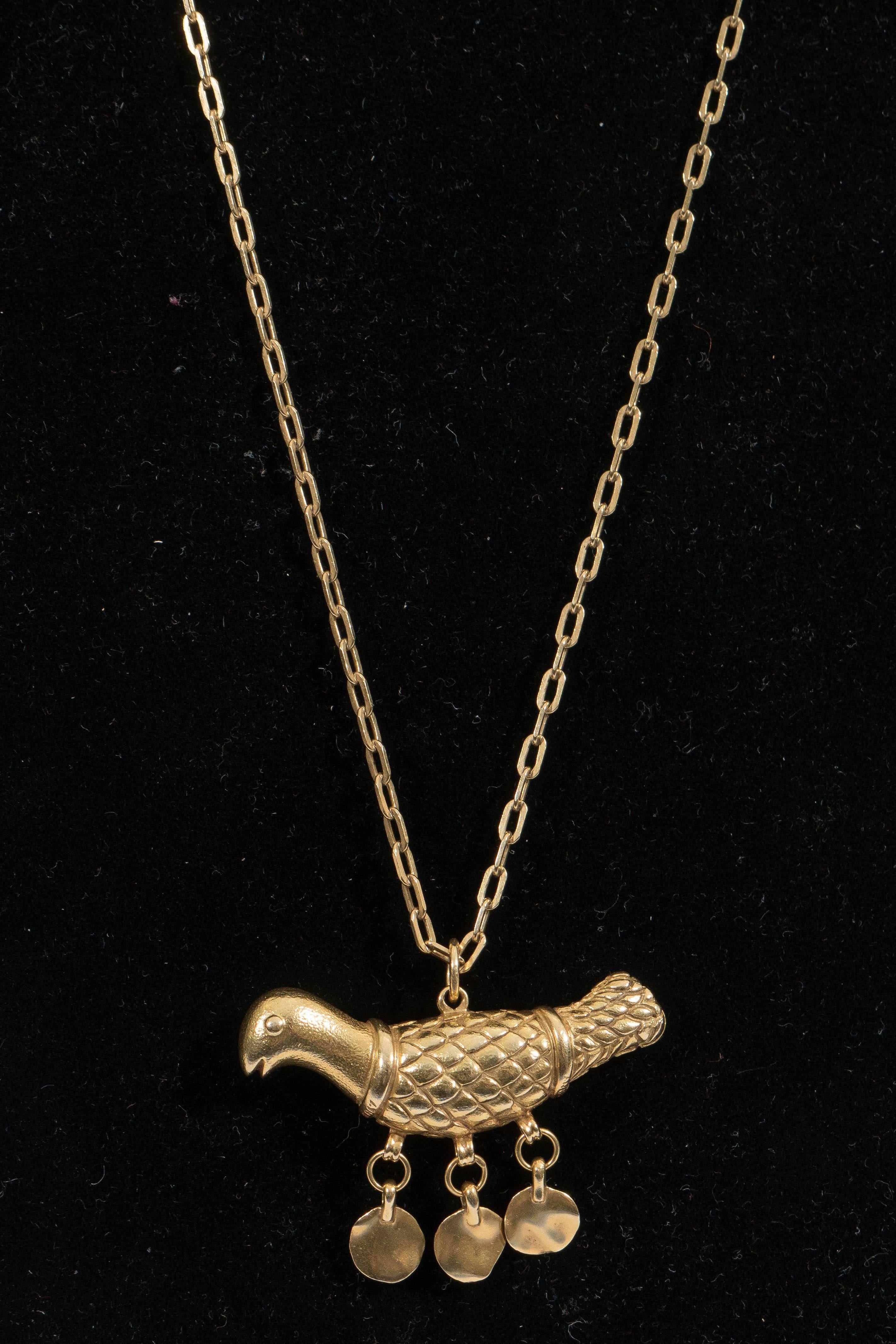 A vintage Tiffany necklace, produced in Italy, with stylistically detailed bird pendant and lengthy chain, entirely in 18-karat yellow gold, trimmed with three dangling hammered discs. Markings include [TIFFANY] and [K18 ITALY] stamped to the