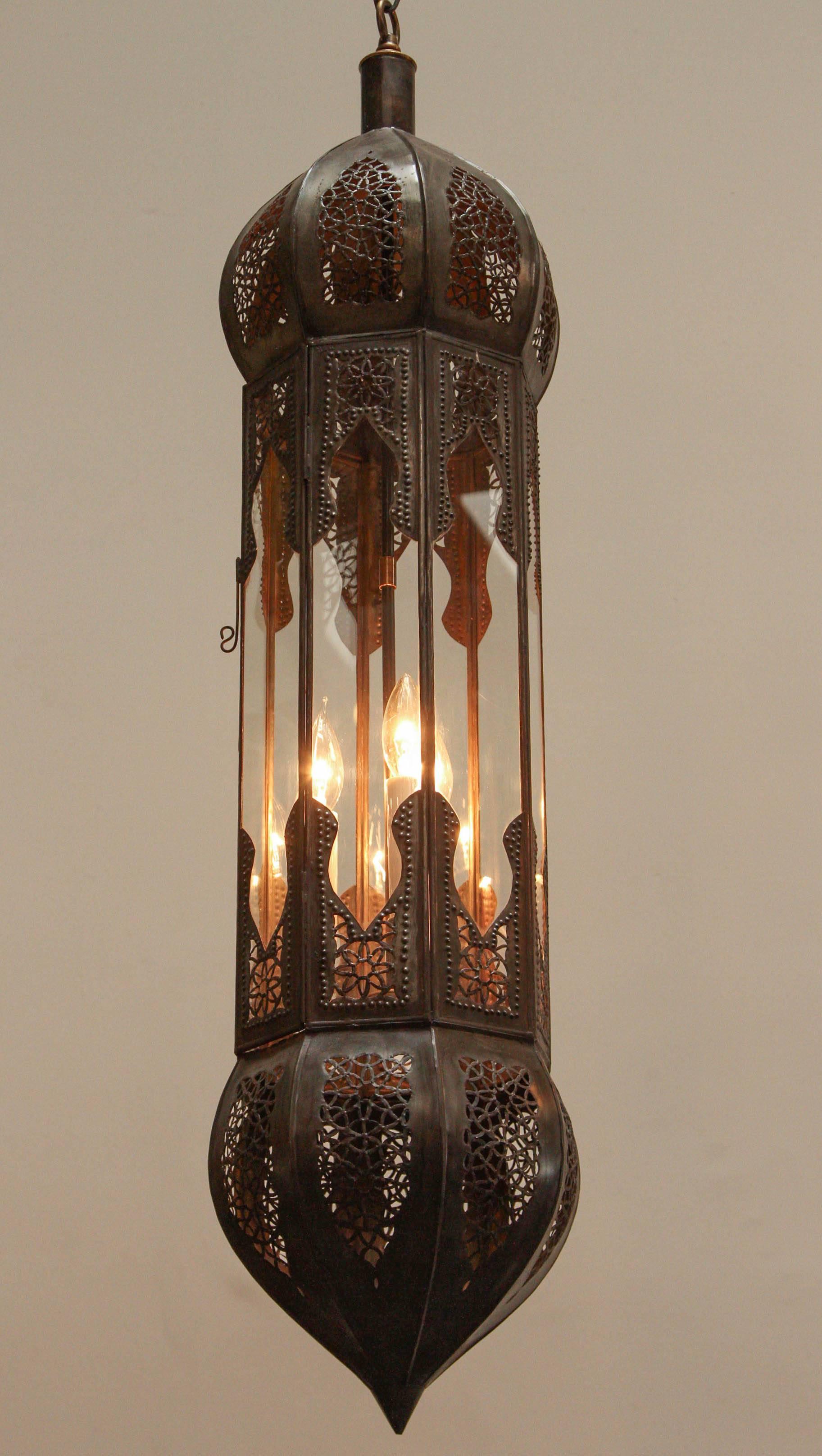 Grand et long pendentif marocain en métal mauresque et verre transparent, fabriqué à la main à Marrakech, au Maroc, par des artisans talentueux, métal taillé à la main en filigrane de motifs mauresques.
La couleur du métal est le bronze
