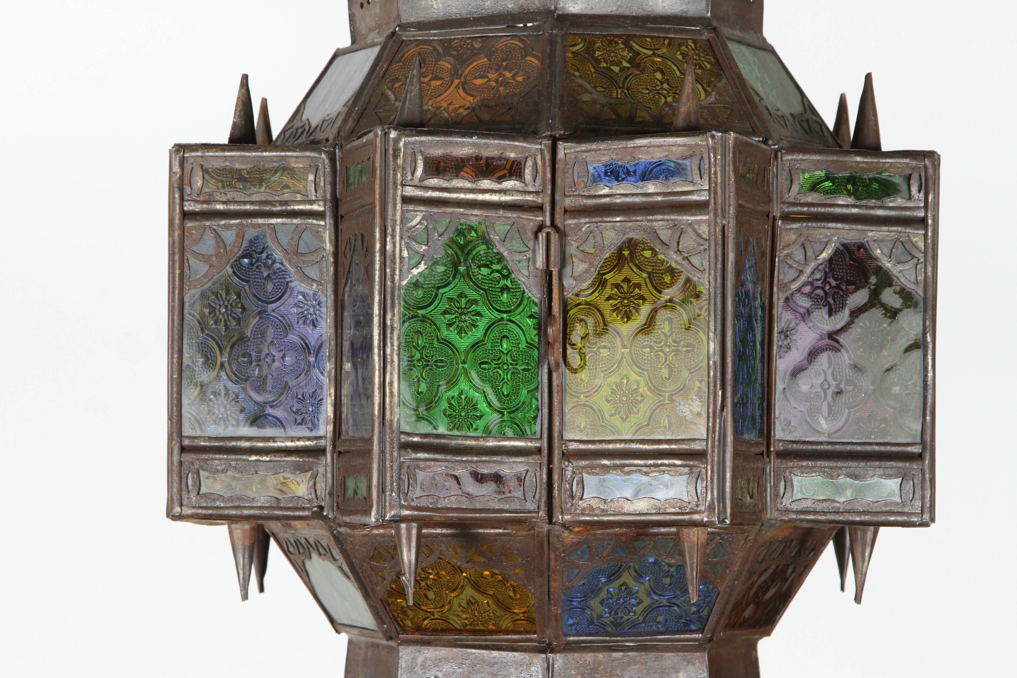 Handcrafted Moroccan glass pendant light fixture, very fine Moorish filigree metal hand-cut in Moorish designs.
Handmade in Marrakech by talented artisans, dark bronze color patina and multi-color glass in green, blue, lavender and amber