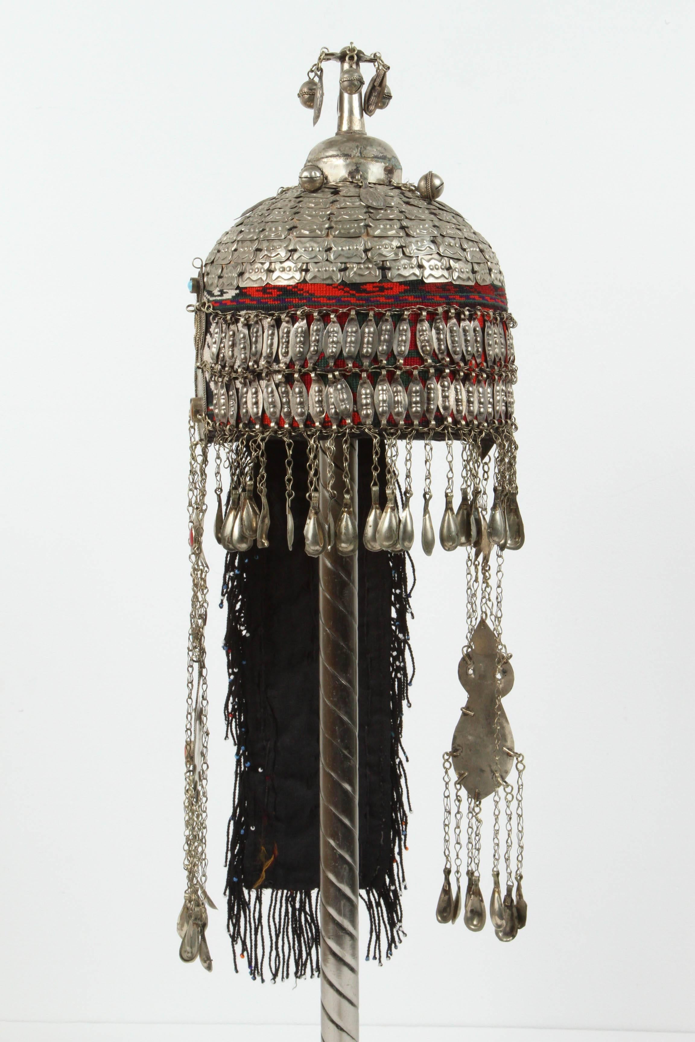 Ceremonial Wedding Ethnic Mongolian head dress and necklace mounted on stand
The headdress is shaped somewhat like a helmet covered with hand woven fabric and is totally encrusted with silver buttons, ornaments, coins and beads, 
