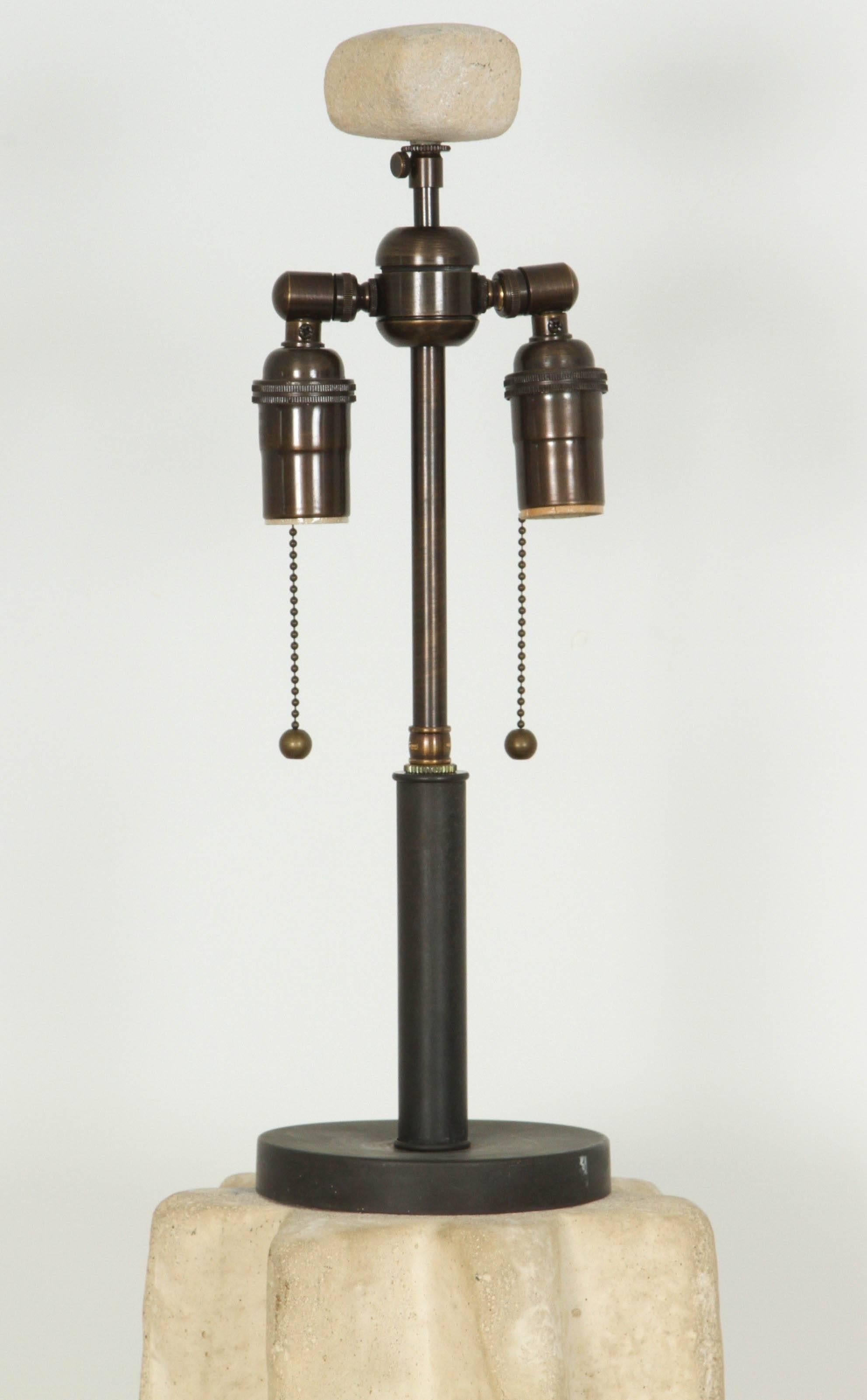 Grande lampe de table cannelée en pierre brute de Michael Taylor 
La lampe a été recâblée avec  une double grappe en bronze antique, et possède un épi de faîtage en pierre assorti.
Il y a des fissures mineures et des ébréchures consistantes  avec