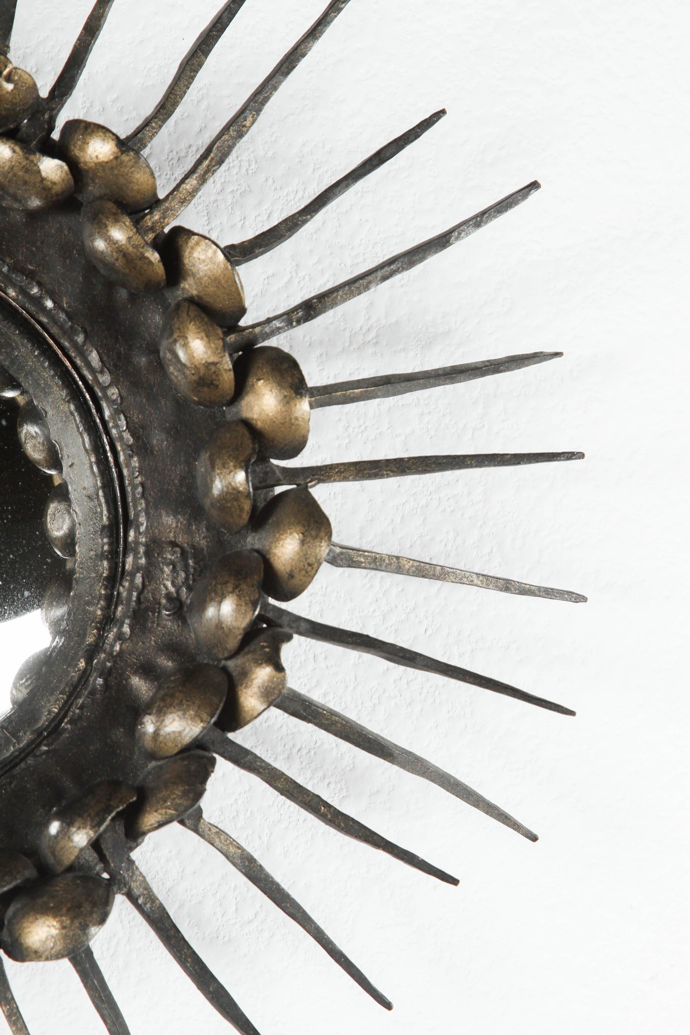  Small Convex sunburst mirror with a frame of spikes, with large brass nailheads.