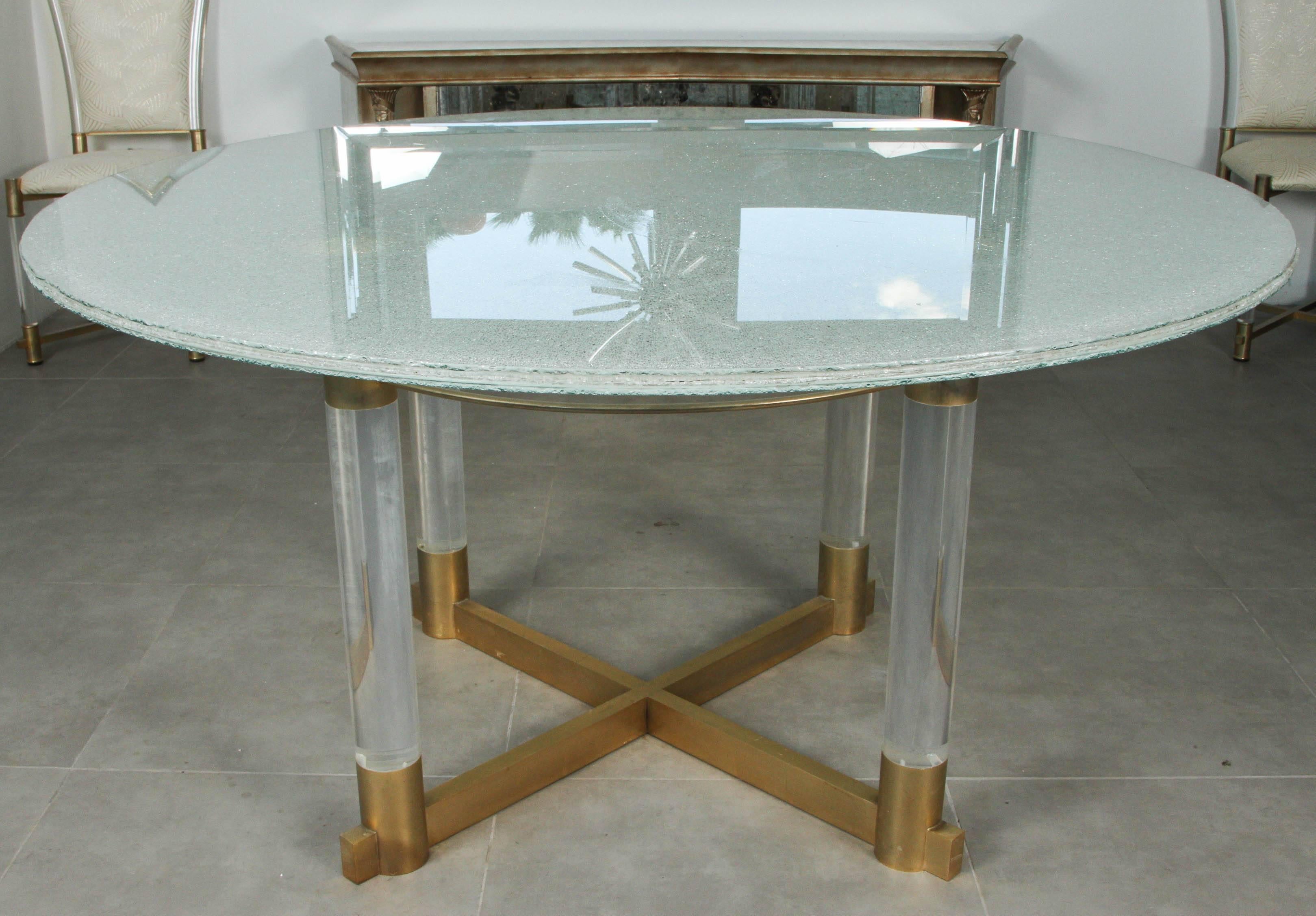 Crackled glass dining table with a base of thick lucite cylinders and brass fittings.