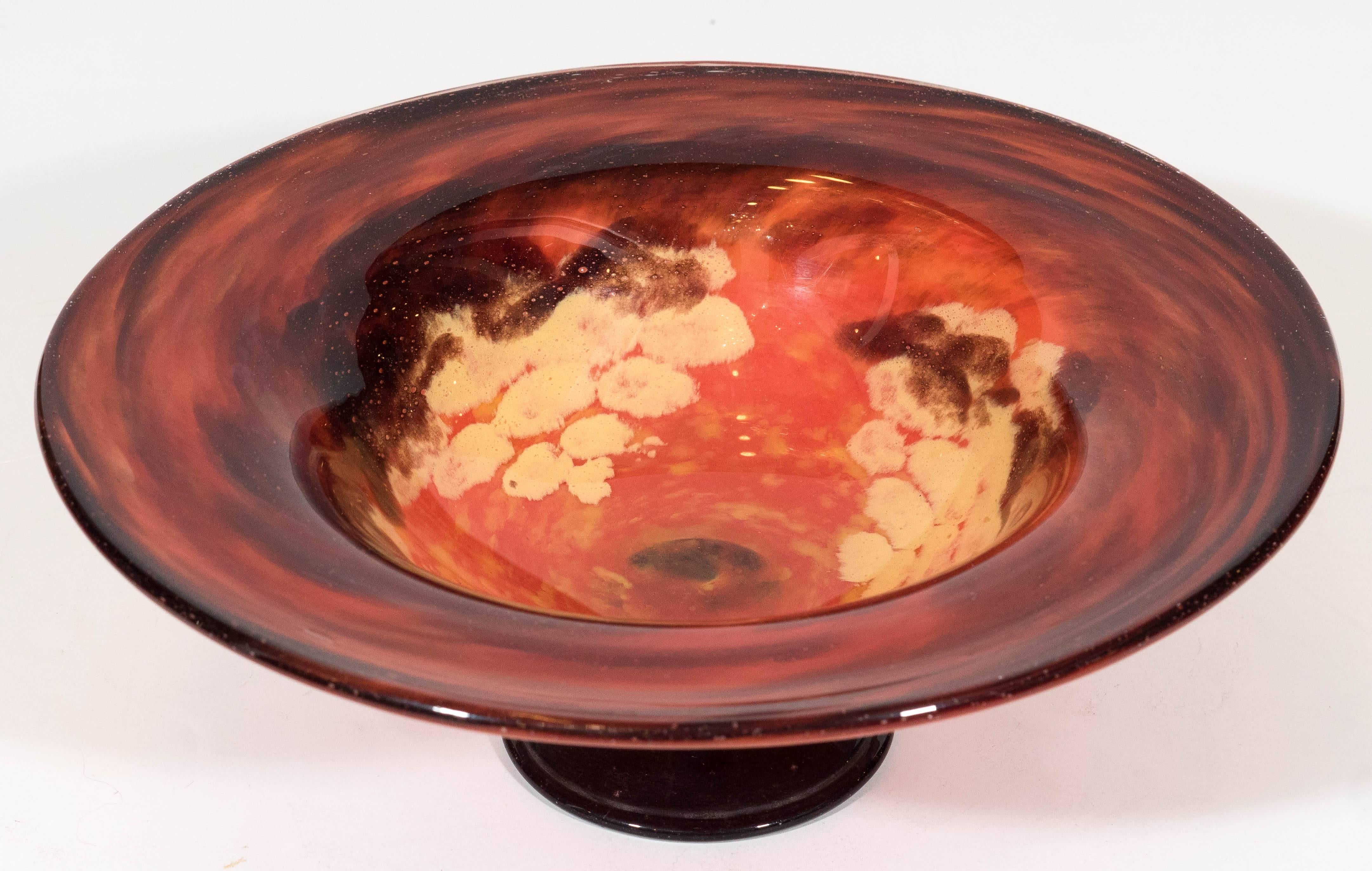 A vintage circa 1930s-1940s French art glass bowl, produced by Schneider Glass, the convex body, detailed with mottled tones of red, gold and black, on a raised pedestal base in black. Markings include [Schneider], etched to the bottom of the bowl,