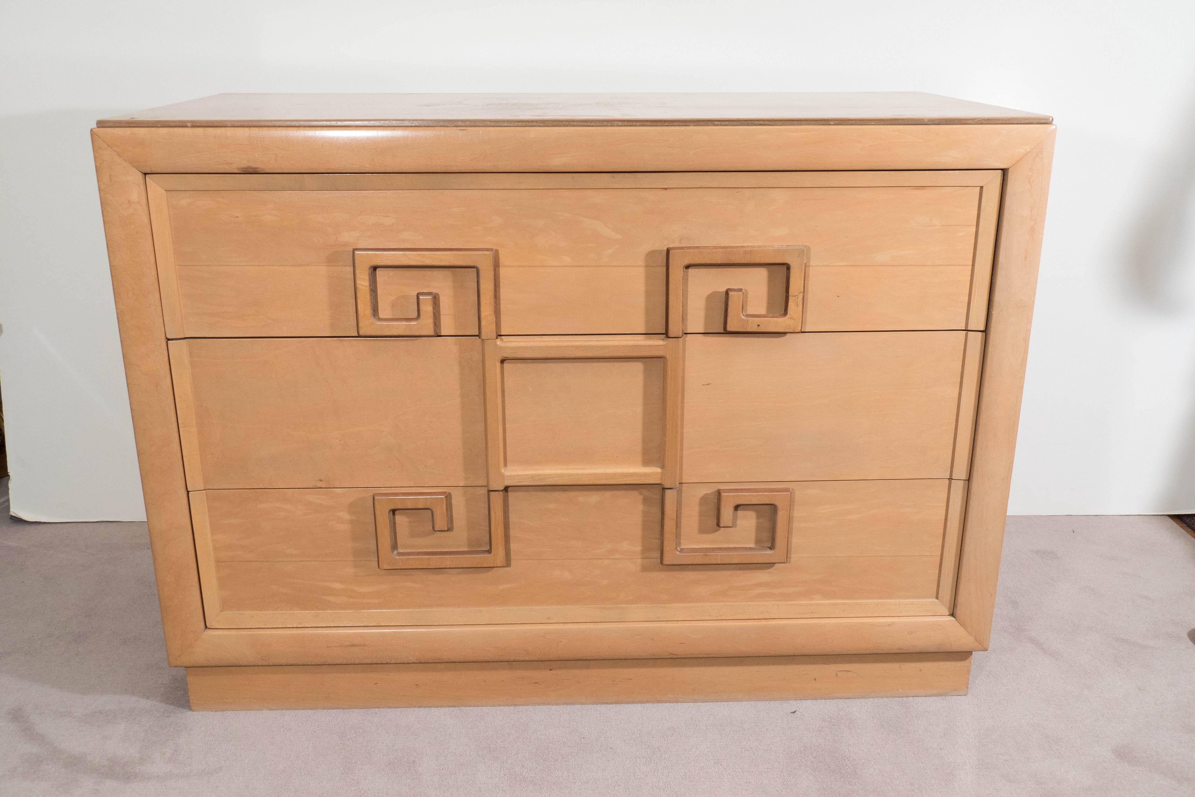 A pair of vintage chests in light toned wood, produced circa 1940s by Kittinger, including three exterior drawers, with decorative handles fashioned as a Greek key designs. Markings include [Kittinger/1866, Buffalo] stamped to the interior of one of