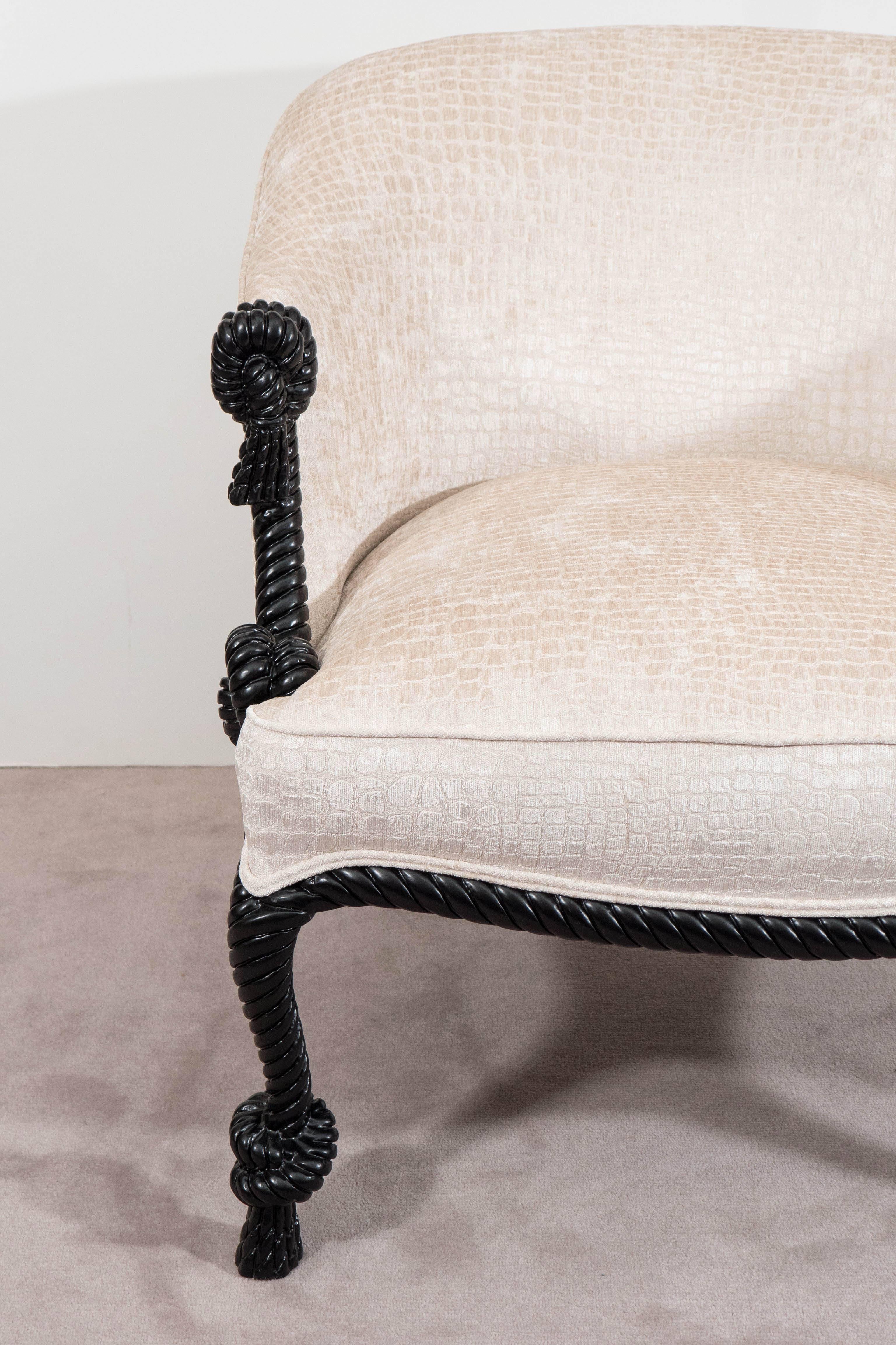 A vintage Italian barrel back armchair, designed in the Napoleon III style, upholstered in very chic, bone-white fabric with faux alligator skin patterns, against a carved and black painted wood frame, detailed with rope and tassel motif. Very good