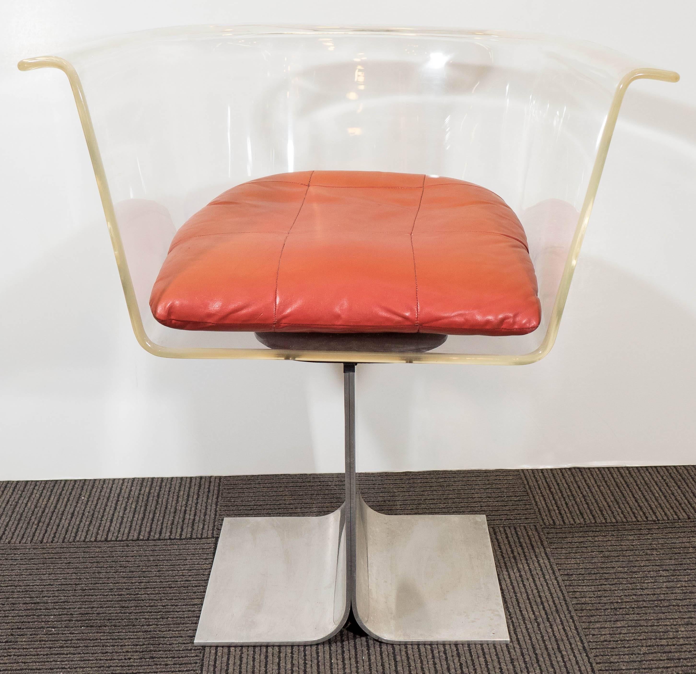 A vintage, highly modernistic barrel-back swivel armchair, produced circa 1970s by Pace Collection, in curved acrylic, with a salmon colored leather seat, on an aluminum base, consisting of two curved panels. Overall good condition, with age