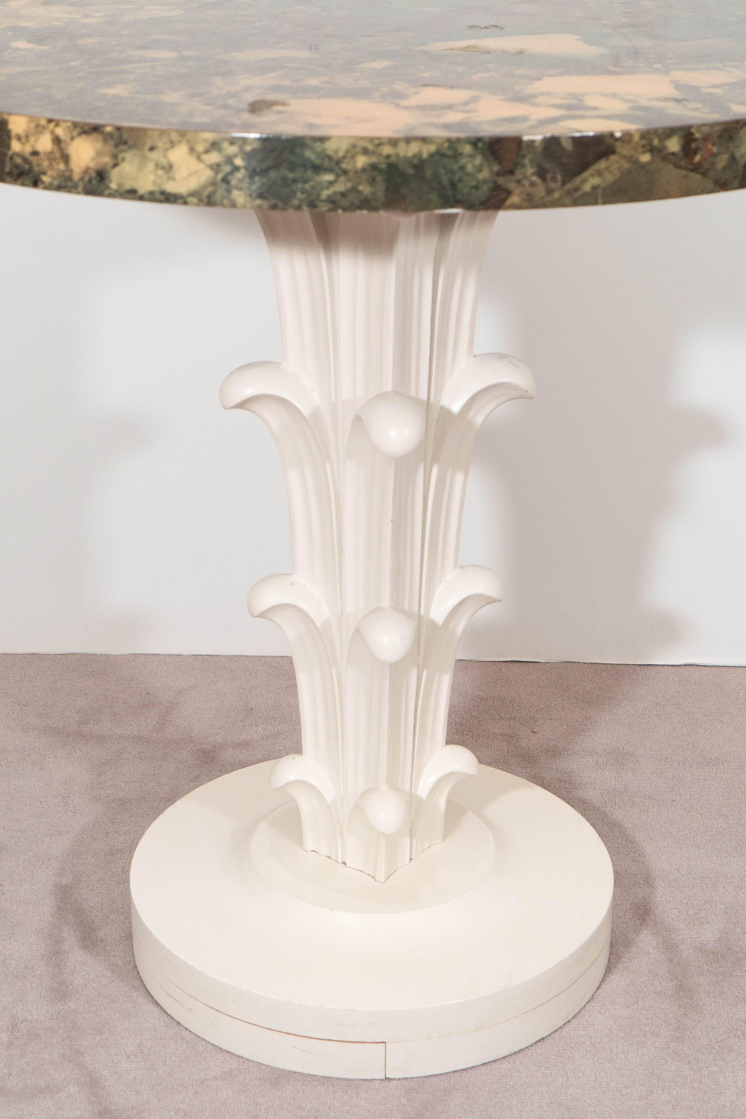 A pair of vintage pedestal tables, produced by Widdicomb Furniture, circa 1950s for retailer John Stuart, each with faux verde marble patterned surface, over leafy table bases in white painted carved wood. Good vintage condition, with age