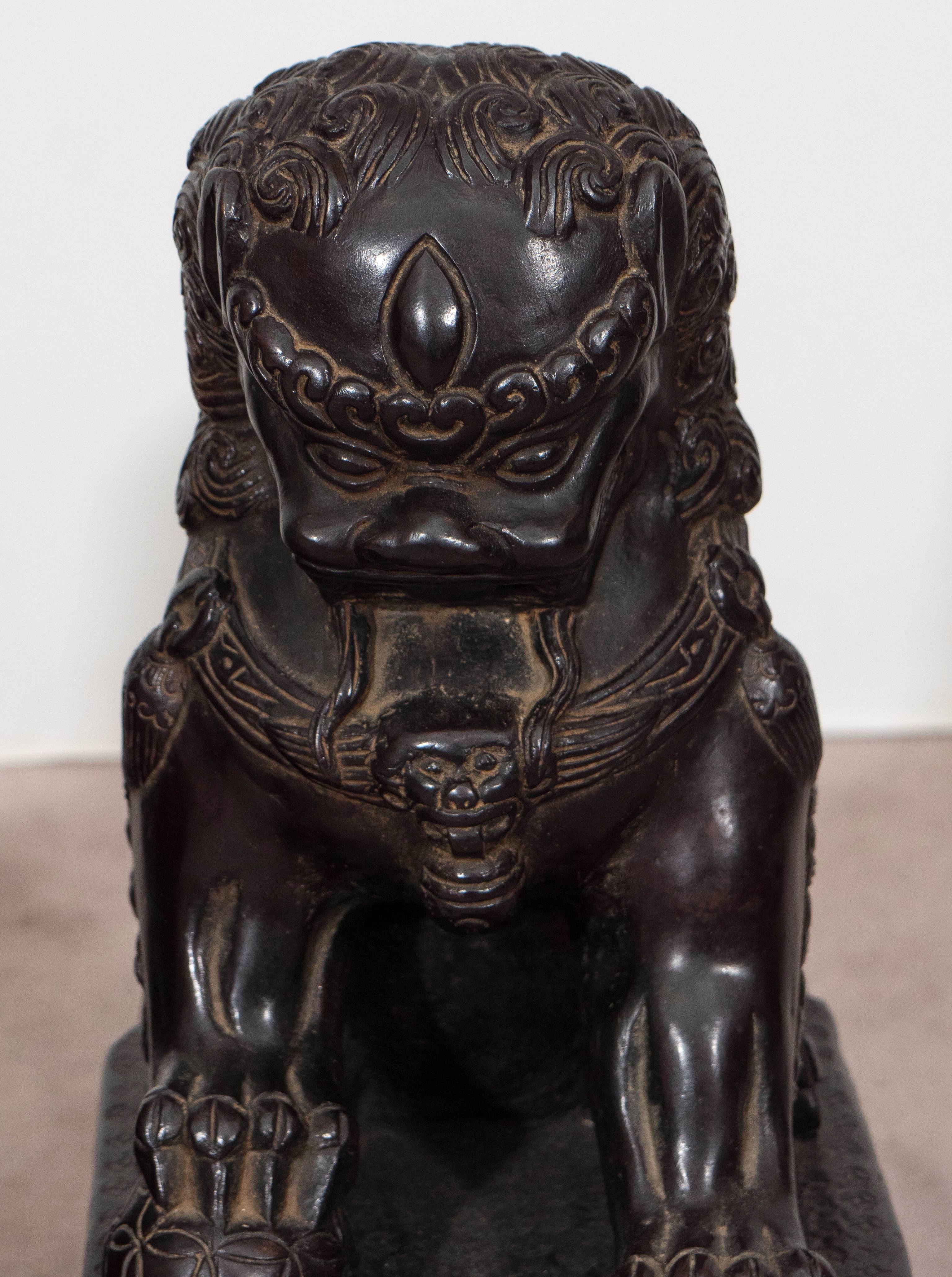 A pair of Foo (alternatively 'Fu') Dog statues, the western name for Chinese Imperial Guardian Lions, in beautiful cast bronze, each depicted standing on highly detailed bases, with felt to the underside of either. In accordance with feng shui