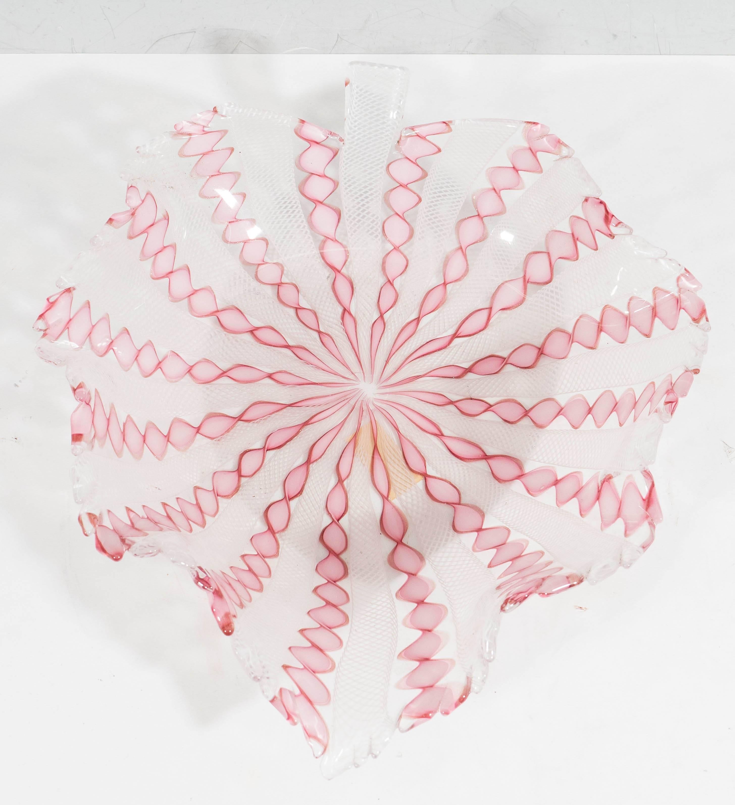 A vintage Venetian handblown Murano glass bowl, beautifully shaped as a ridged and curling leaf, with twisted 'latticino' canework in pink and white. Markings include an adhesive stamp [Made Italy/N. 301/2938], affixed to the underside of the bowl.