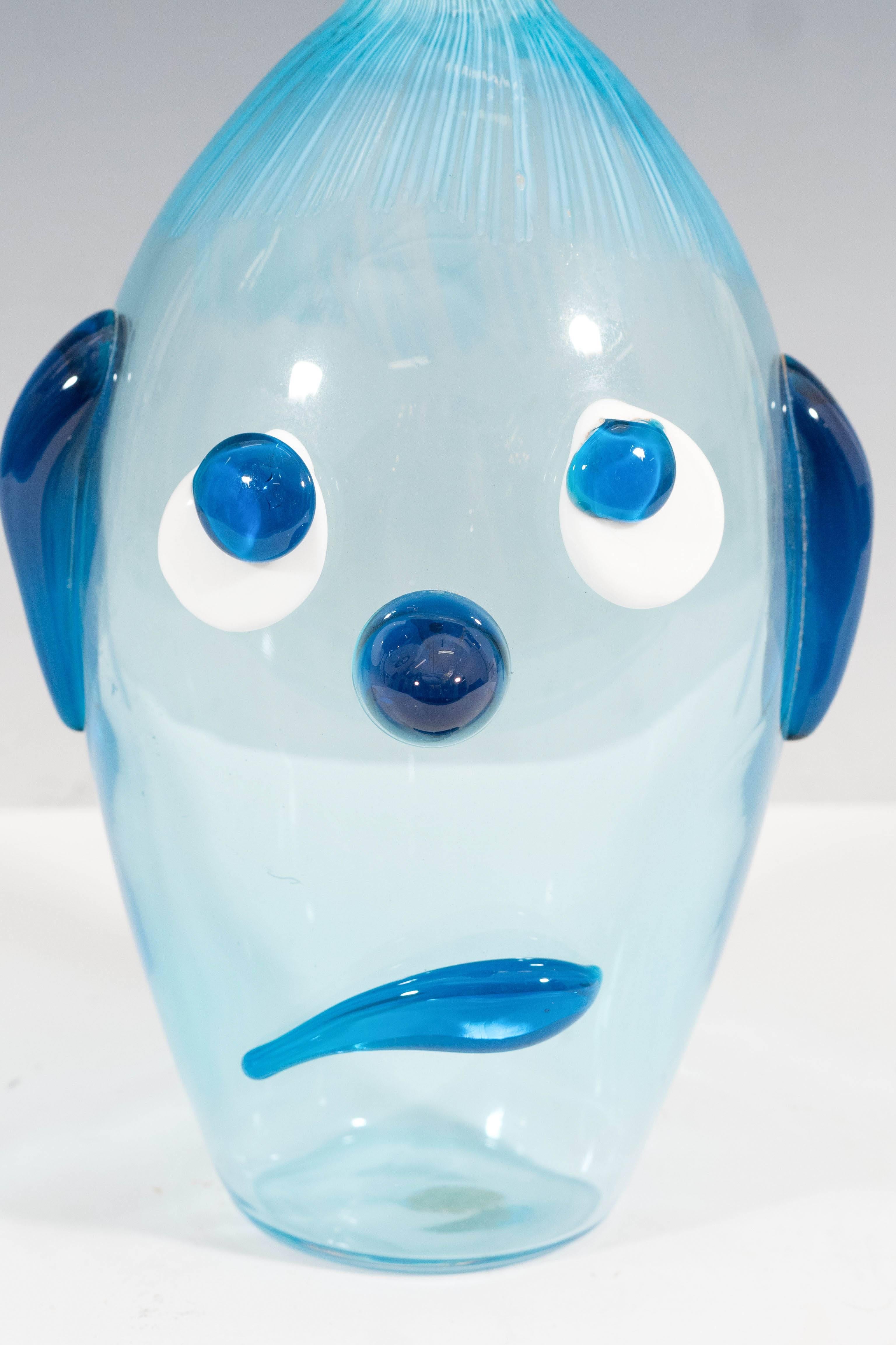 A vintage Murano glass decanter in varying shades of blue, produced in Venice during the 1950s and 1960s by Vetreria Fratelli Toso, with round glass stopper over a handcrafted and blown body, decorated with the features of an expressively sad dog.
