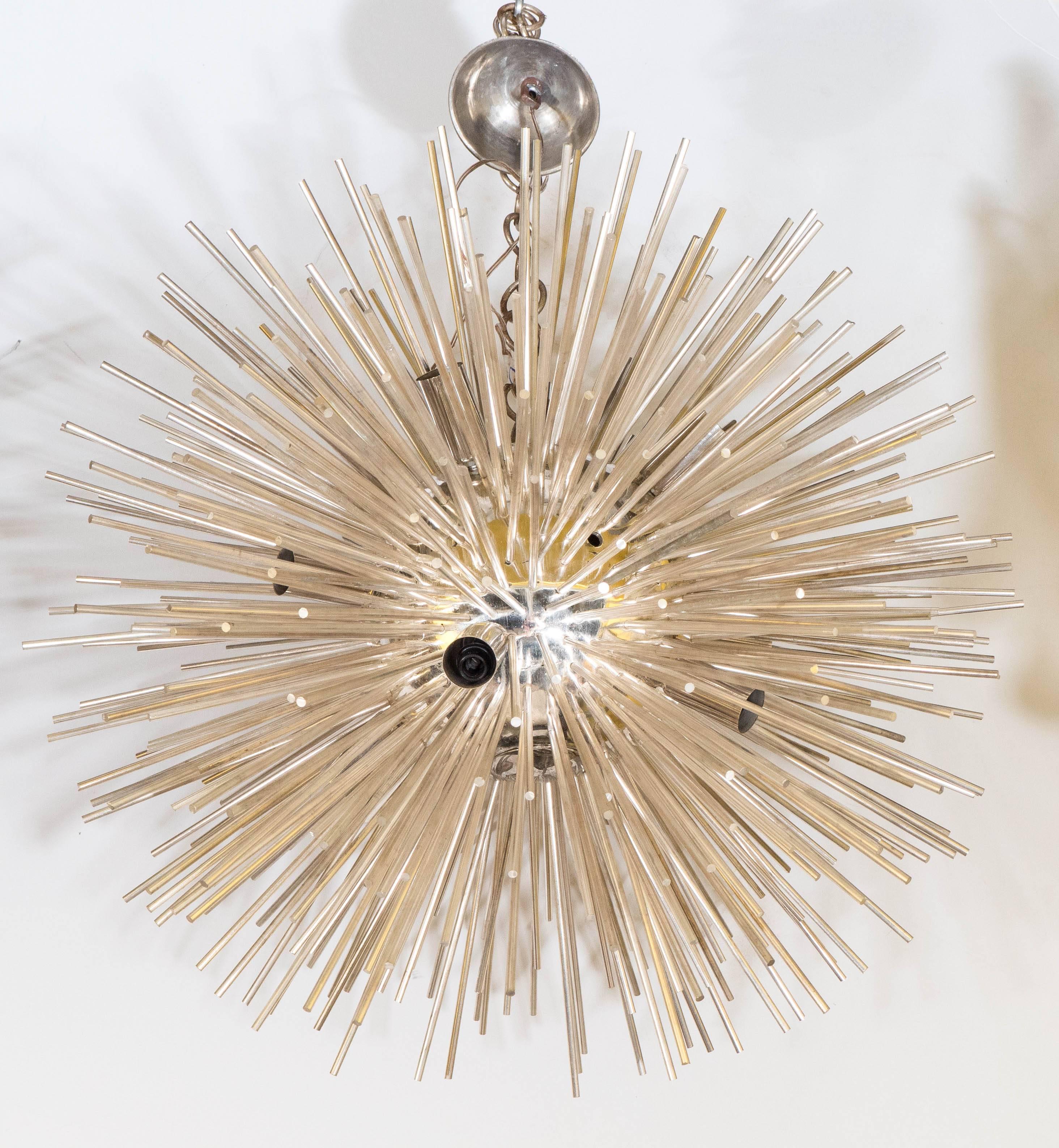 Ce lustre Sputnik italien très moderniste comprend d'étonnantes tiges argentées qui rayonnent à partir d'un noyau central, suspendu à une plaque de plafond circulaire. Très bon état, toute usure présente correspondant à l'âge et à l'utilisation ;