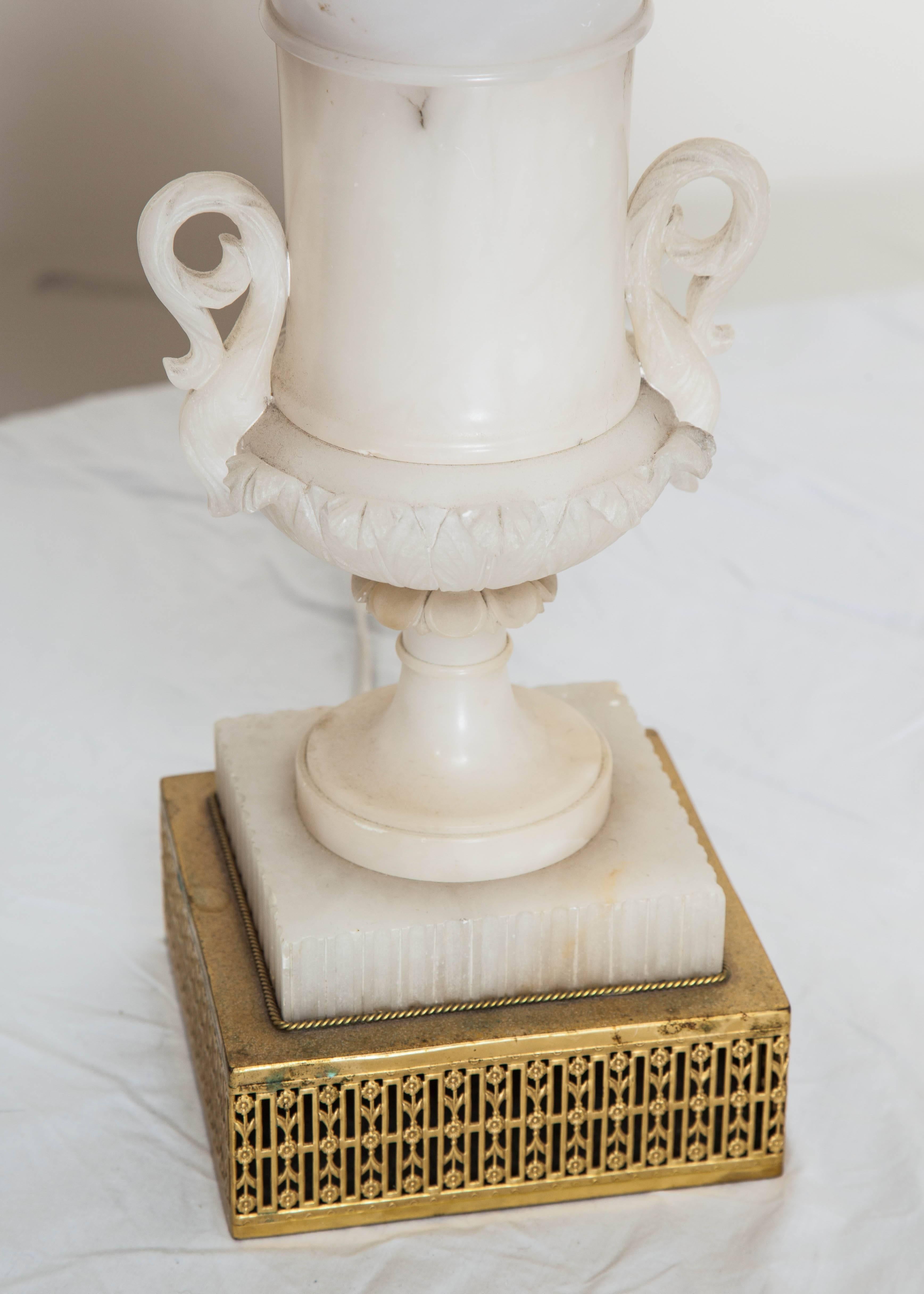 Mid Century American alabaster urn table lamp with detailed brass base and black shade. 1 socket. 