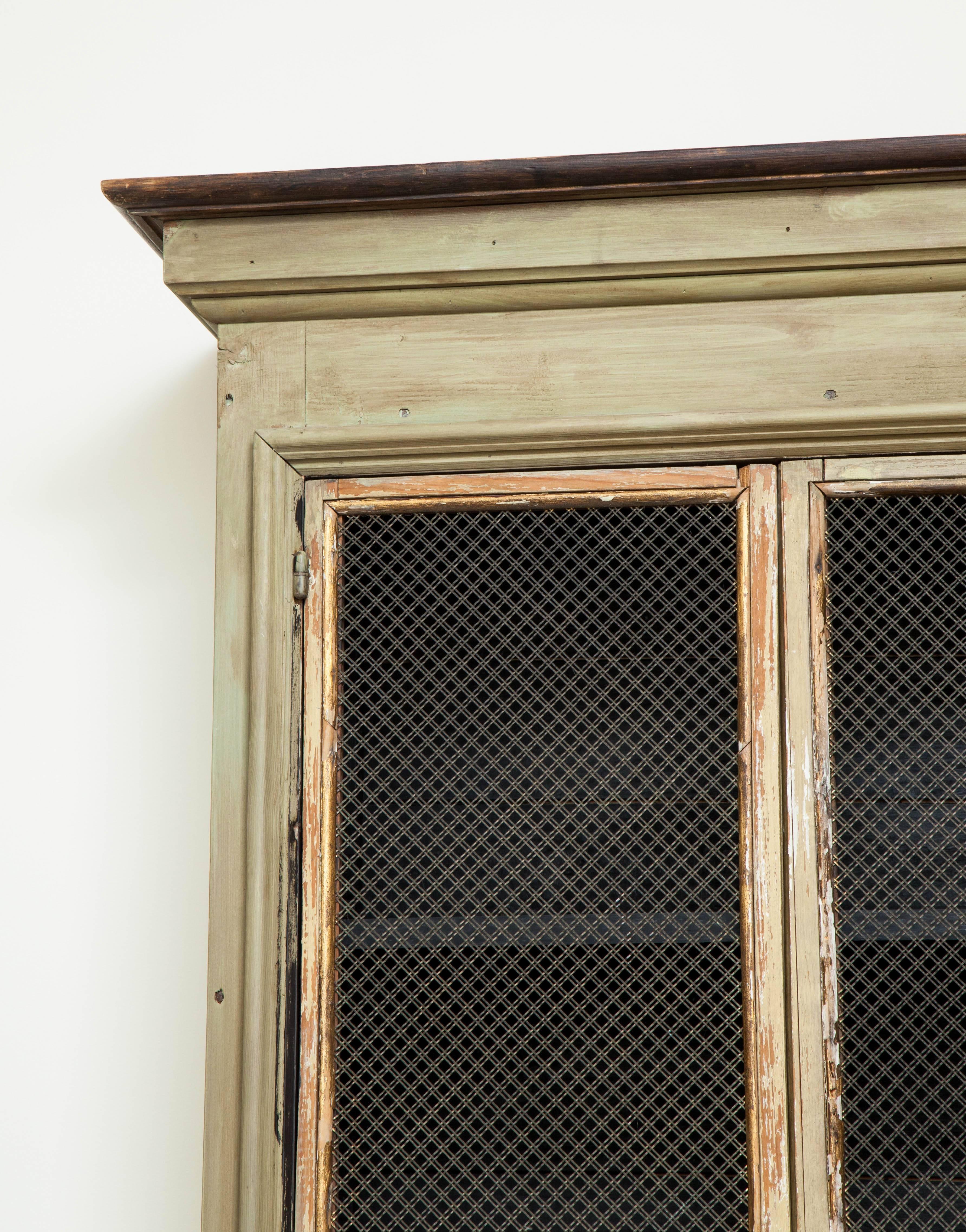 19th century French painted wood bookcases with gilt accents and inset metal grilles. Adjustable shelves six.