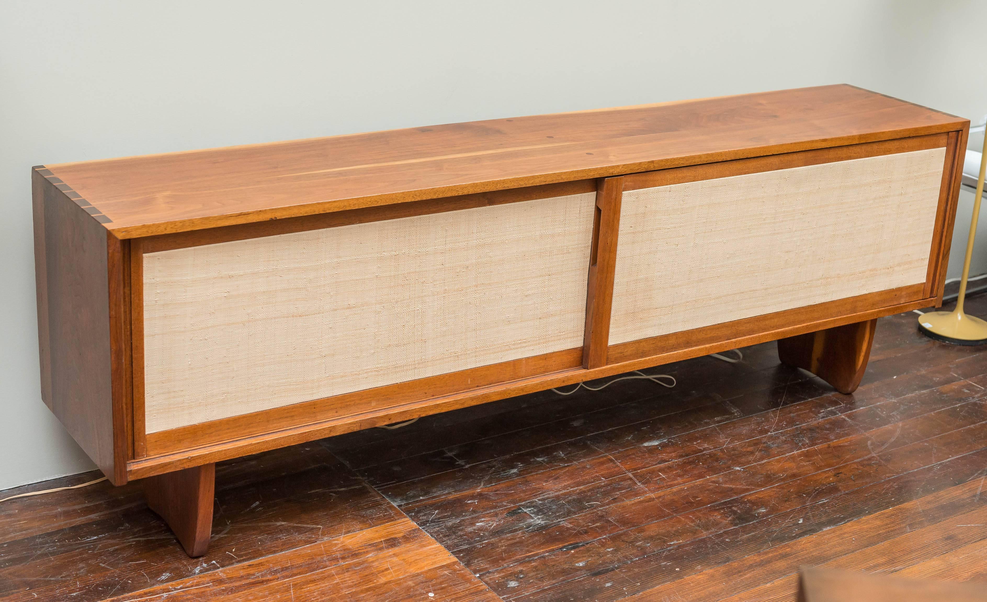 Early George Nakshima design sliding two door sea grass paneled credenza. Simplicity speaks the loudest with his signature highly figured walnut and dove tailed construction combined on organically sculpted legs.
Acquired from the original owners