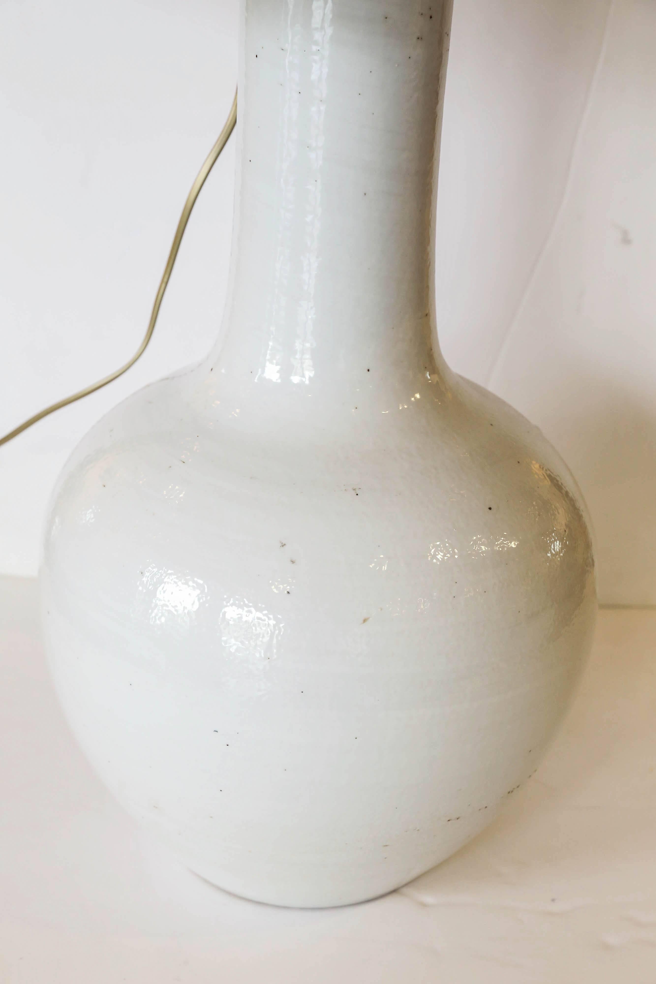 Pair of vintage long neck white vases, newly wired as custom table lamps with shallow drum linen shades.