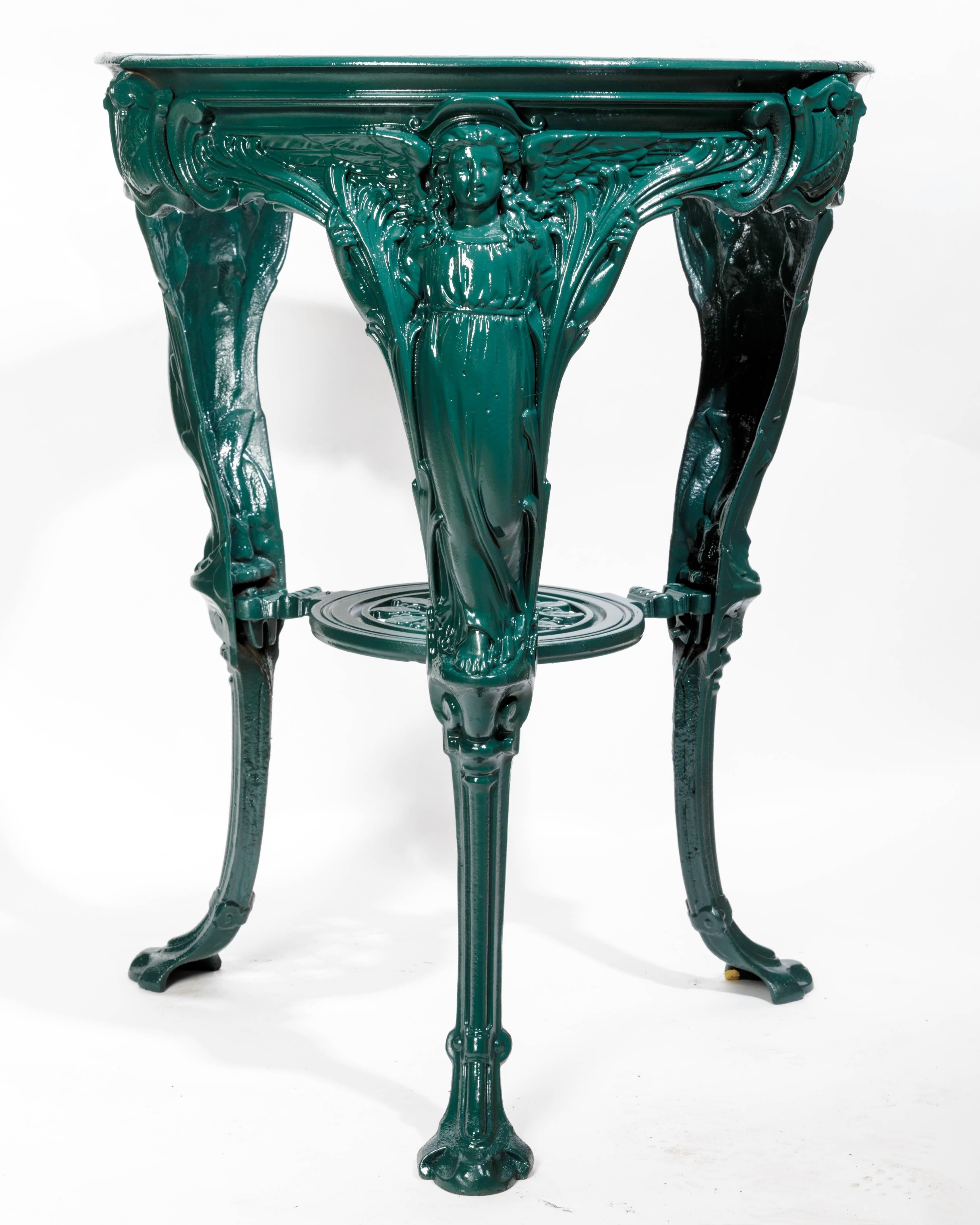 English cast iron round victory pub table in the Art Nouveau style. Each leg is a winged female figure representing victory. The sides are joined by shields with the inscription victory, possibly to celebrate the victory of the Boer or first world