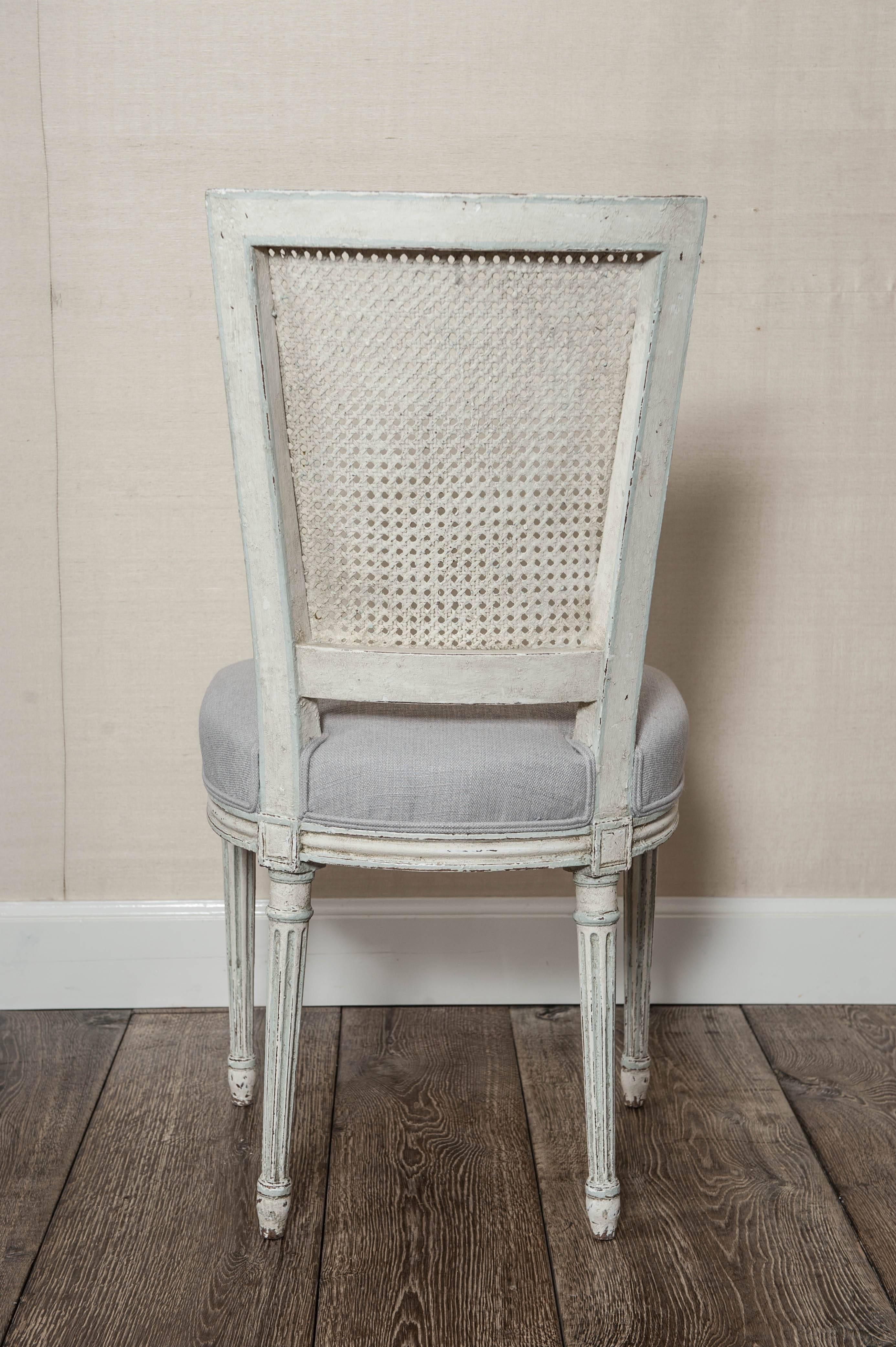 A set of six carved, white painted and (new) linen upholstered French Louis XVI/Seize style dining chairs, 19th century.