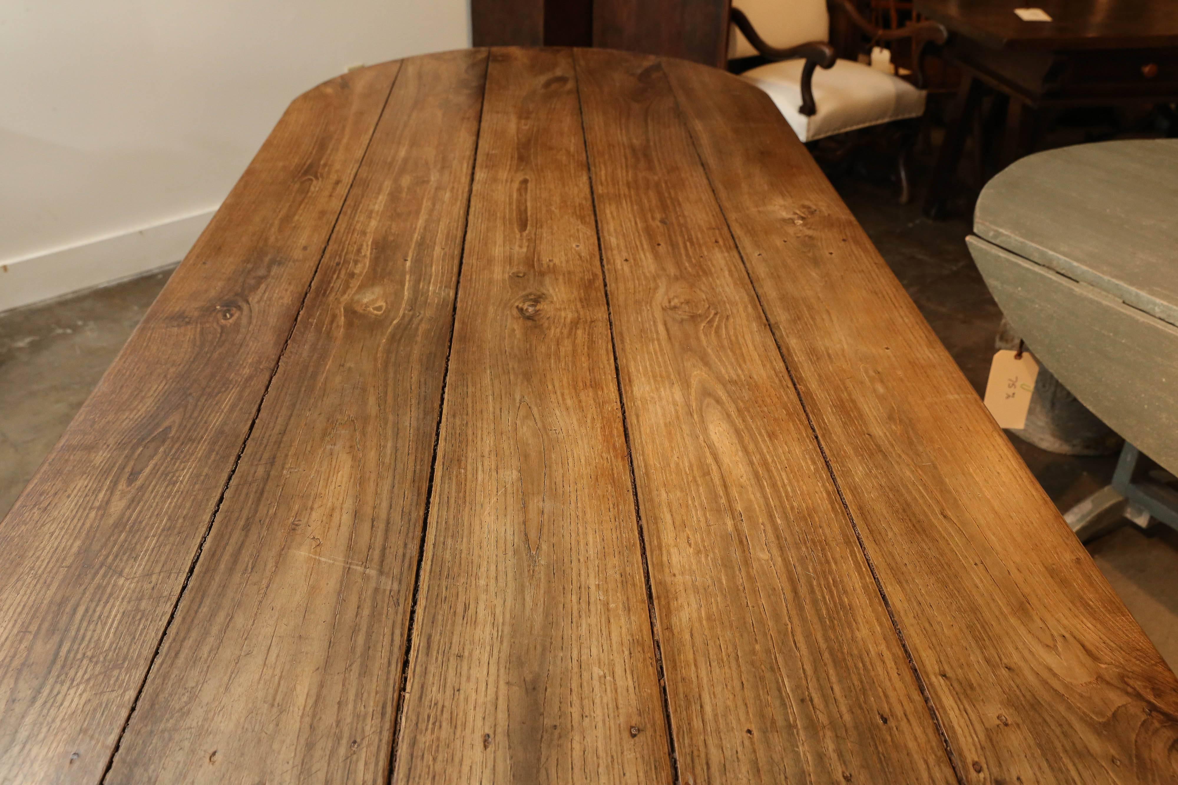 19th century farm table with oval ends. Beautiful patina with areas of bleaching from the sun from years of use. Chestnut. Seats eight-ten.