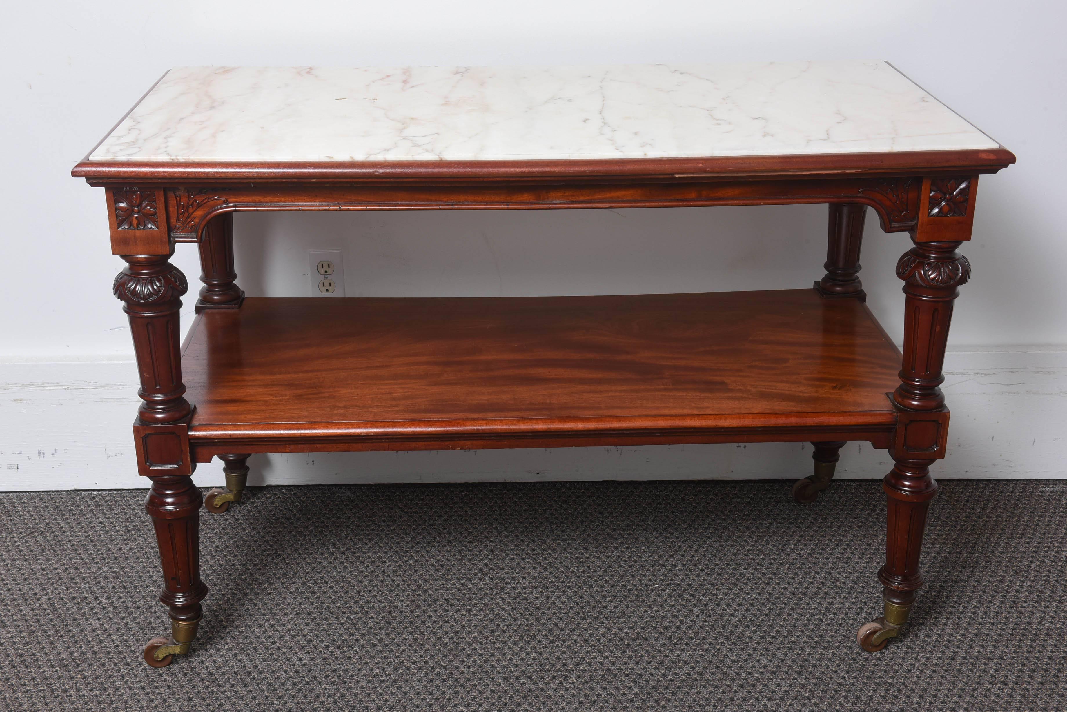 These are an amazing pair of mahogany console tables with a marble top, made in England, circa 1880. The condition is very good, very nice carvings to the fluted leg and the original brass castors to the bottom.
One shelf underneath with the marble
