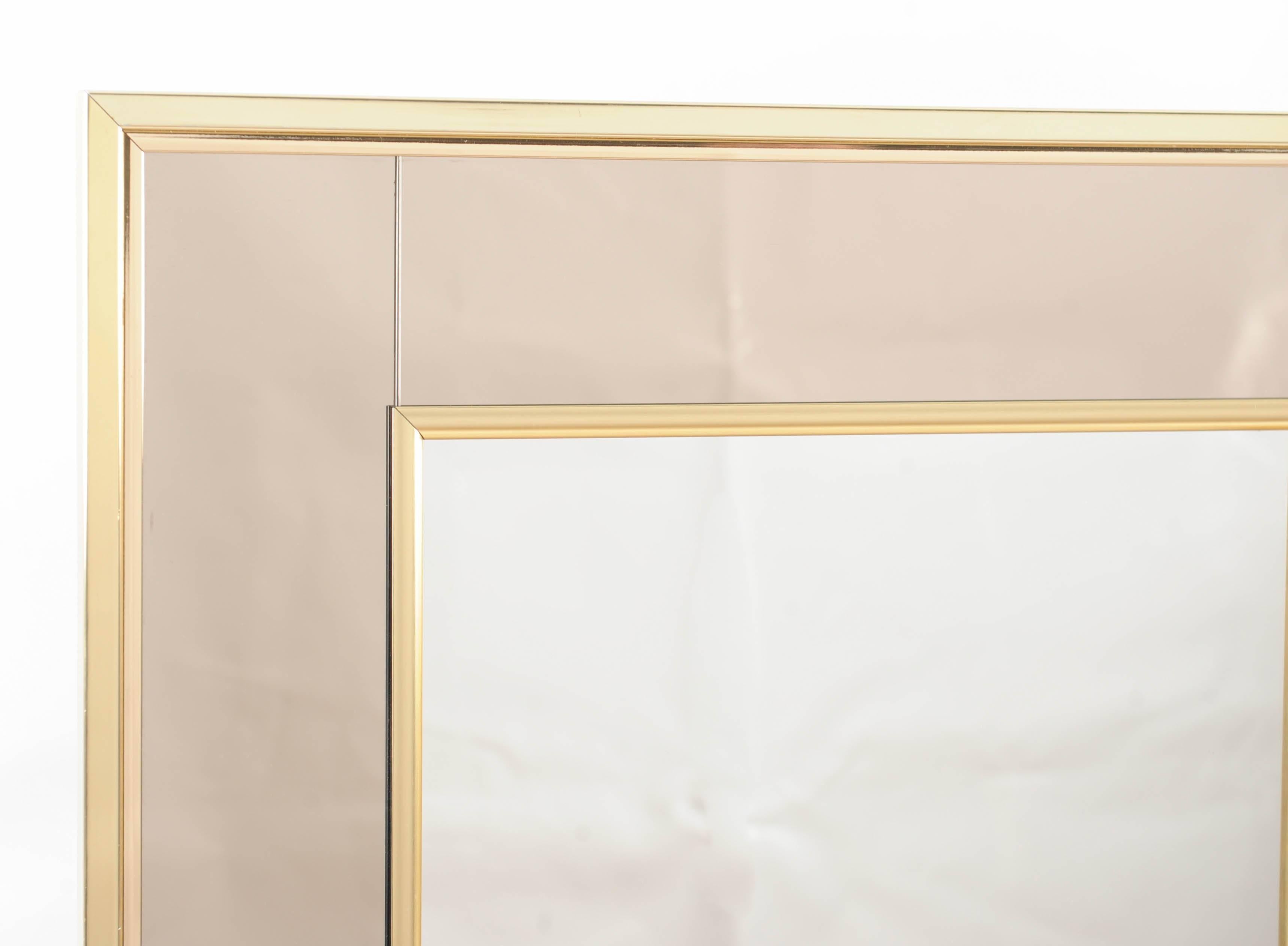 This square mirror has a center made of regular mirror glass which is framed by a champagne coloured outside. All this framed in brass. A magical combination.