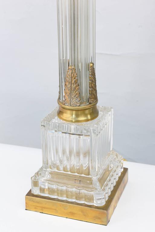 Pair of fluted glass column lamps, each having brass scrolling capital acanthus leaf details, raised on fluted glass plinth and brass base. Shown with shades (not included).

Stock ID: D4720