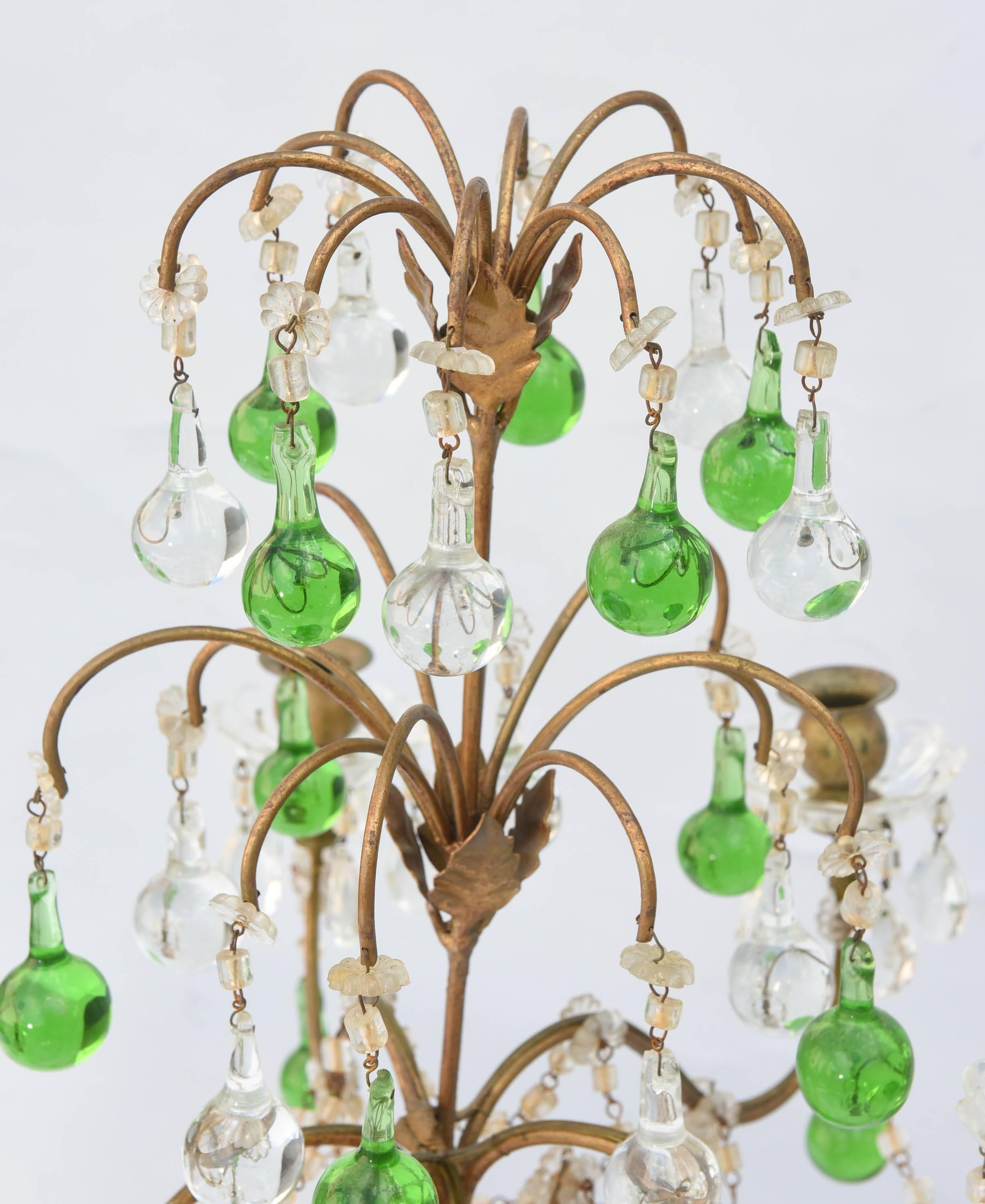 Pair of girandoles, each having center column of painted and parcel gilt turned wood with iron, five scrolling candlearms draped in crystal beads and terminating in glass bobeches; suspended with green and clear crystal balls.

Stock ID: D4681