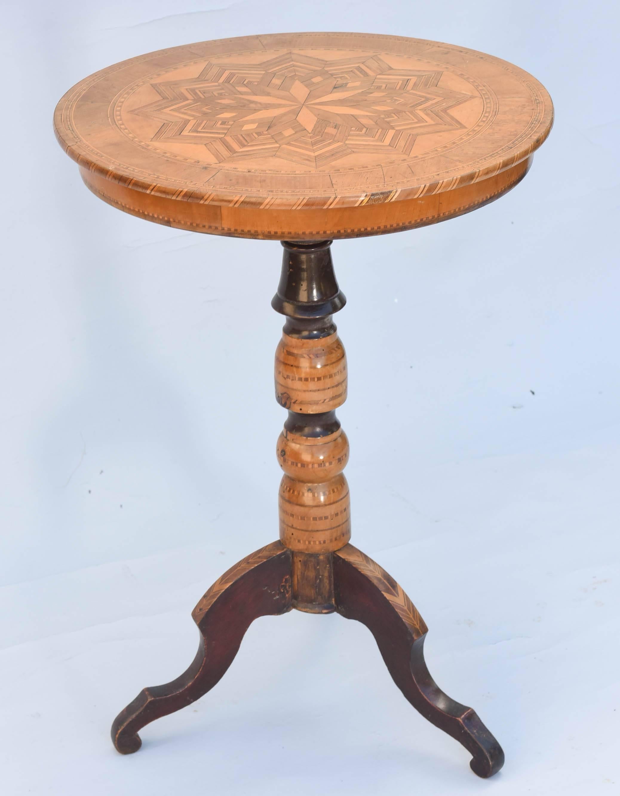 Sorrento table, having round top of beautifully inlaid parquetry of mixed woods in star pattern, raised on turned column with stringing details, on scrolling tripartite base.

Stock ID: D9258