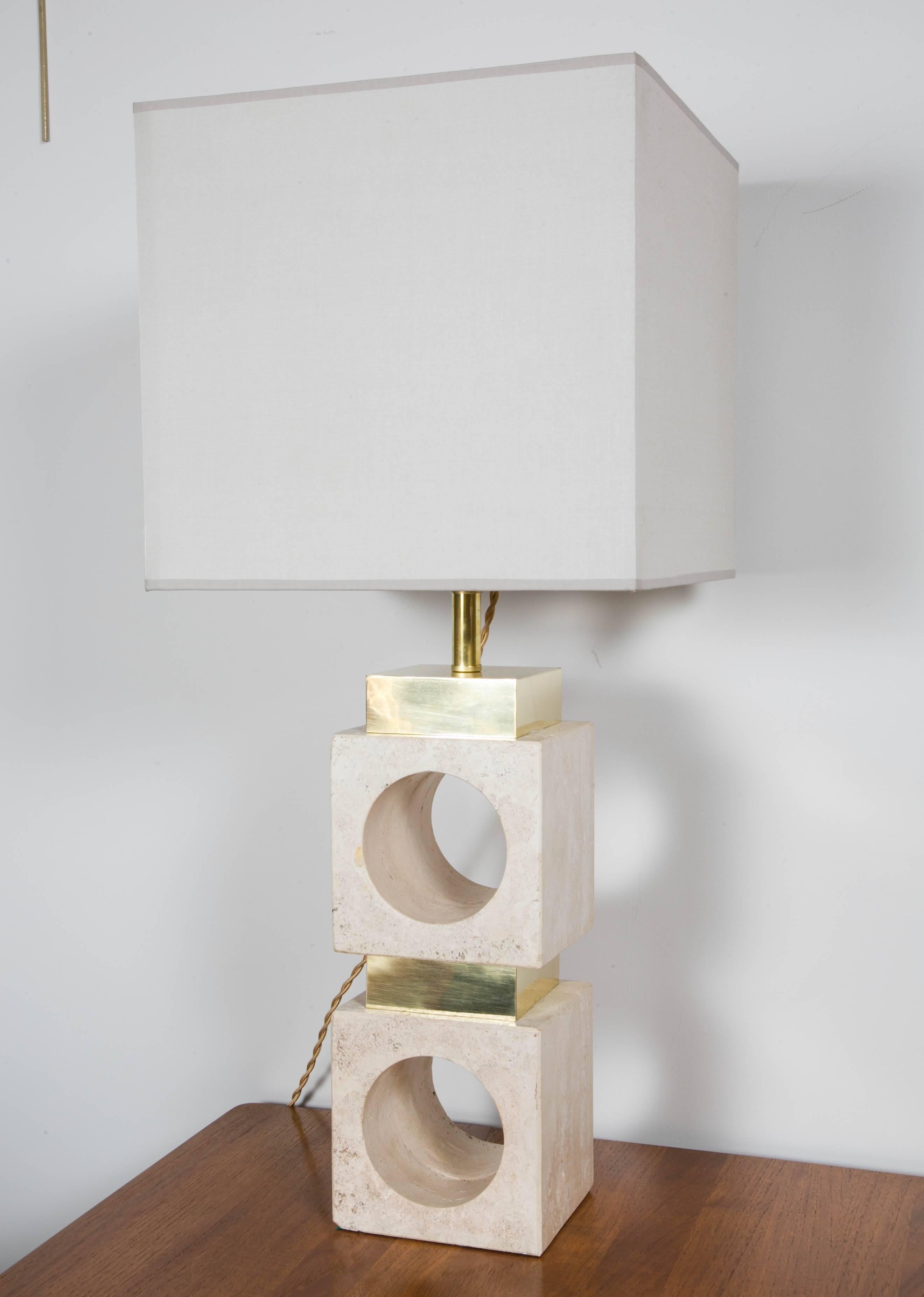 An elegant pair of table lamps , 
 made of two brass-mounted travertine blocks .
Italy, circa 1970 .
Rewired , new shades .