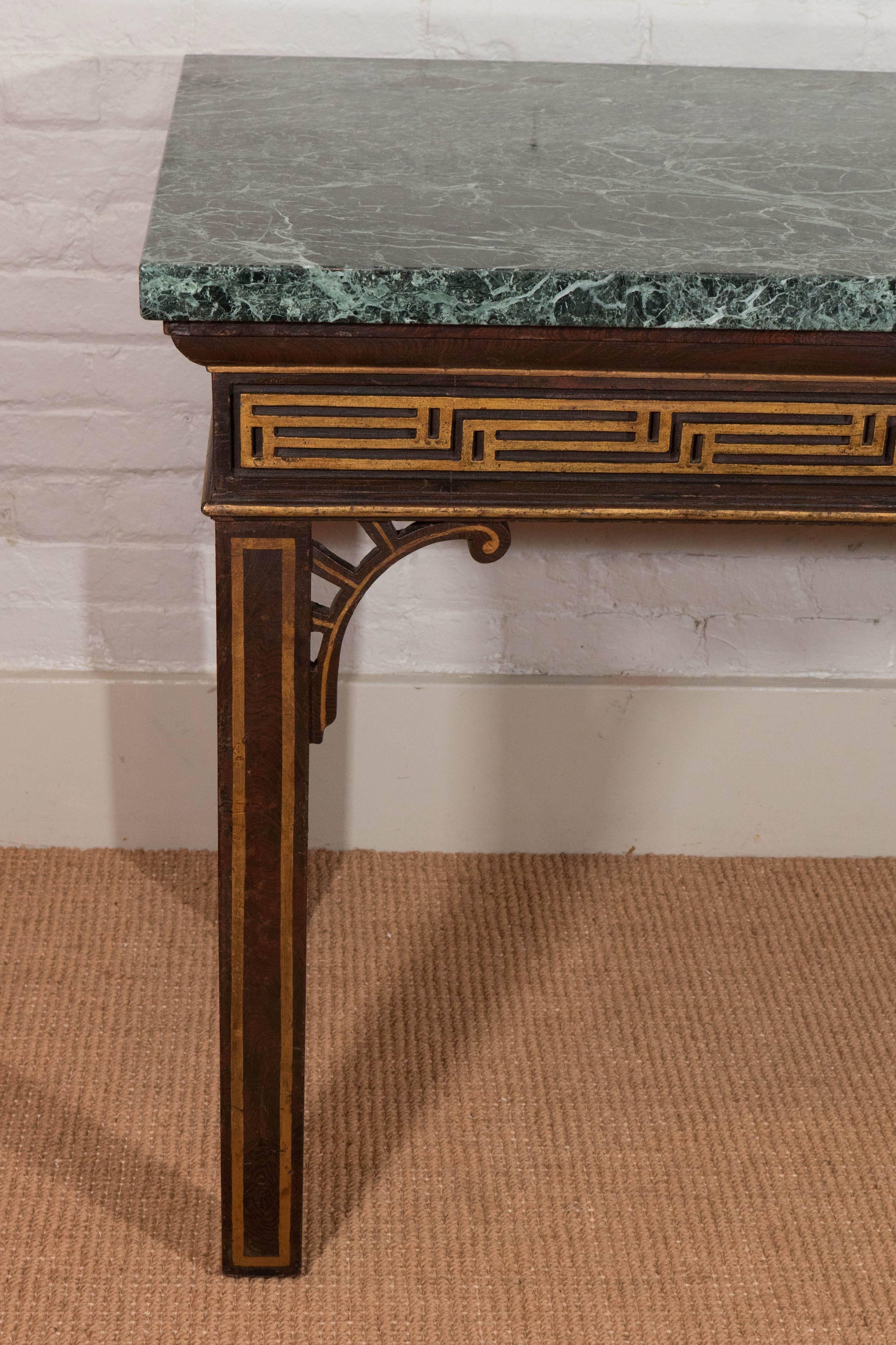 A pair of chinoiserie faux rosewood painted and gilt console tables with Verde Antico marble tops incorporating 18th century elements. The frieze decorated with gilt blind fret carving.