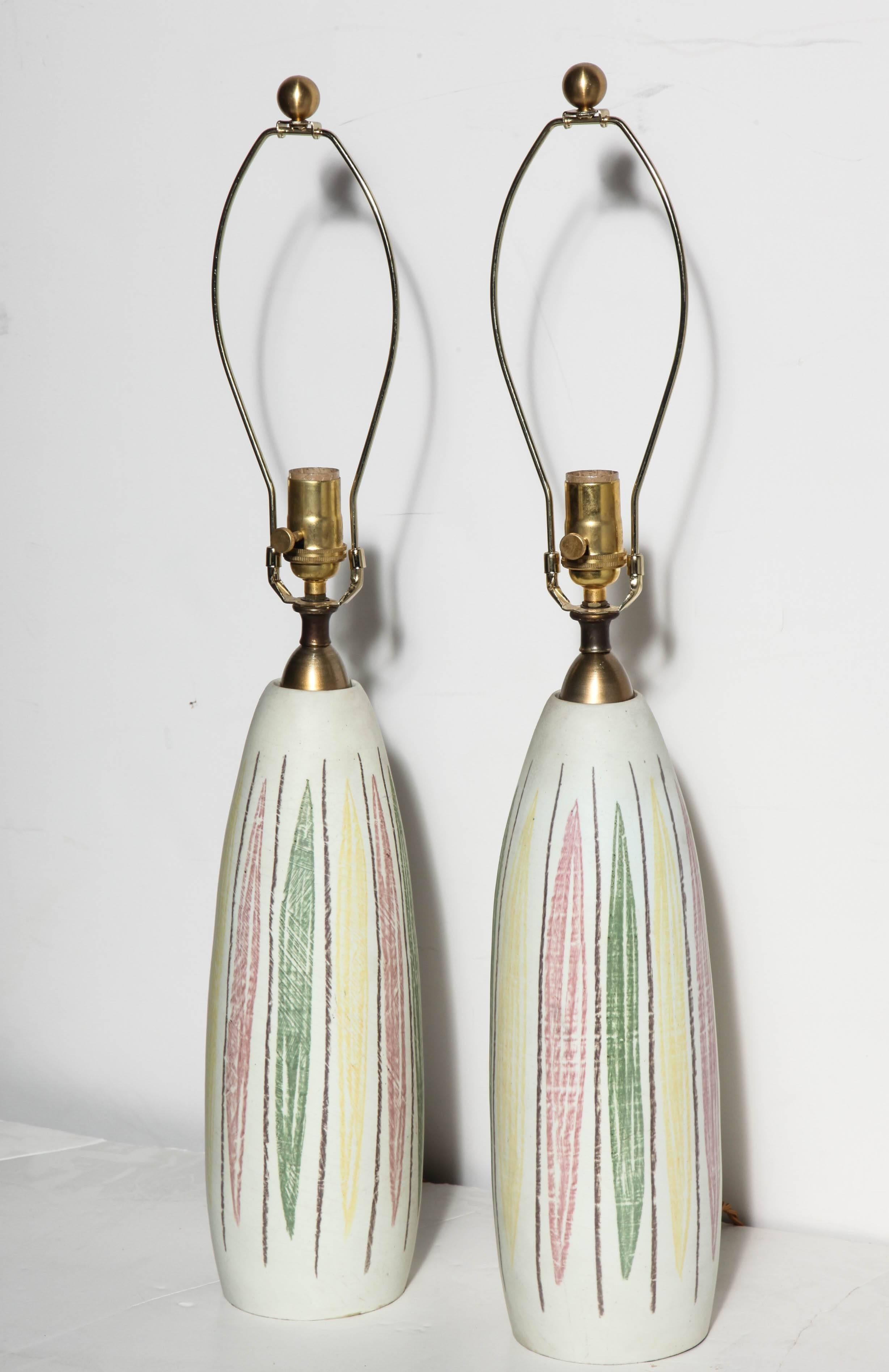 Pair of colorful bottle form Cream Italian Modern Ceramic Table Lamps. Highlighted with free hand organic leaf shaped patterns in Pale Green, Light Yellow and subtle Pink; accented with thin Brown vertical lines. Brass stem.  Made in Italy. Rewired