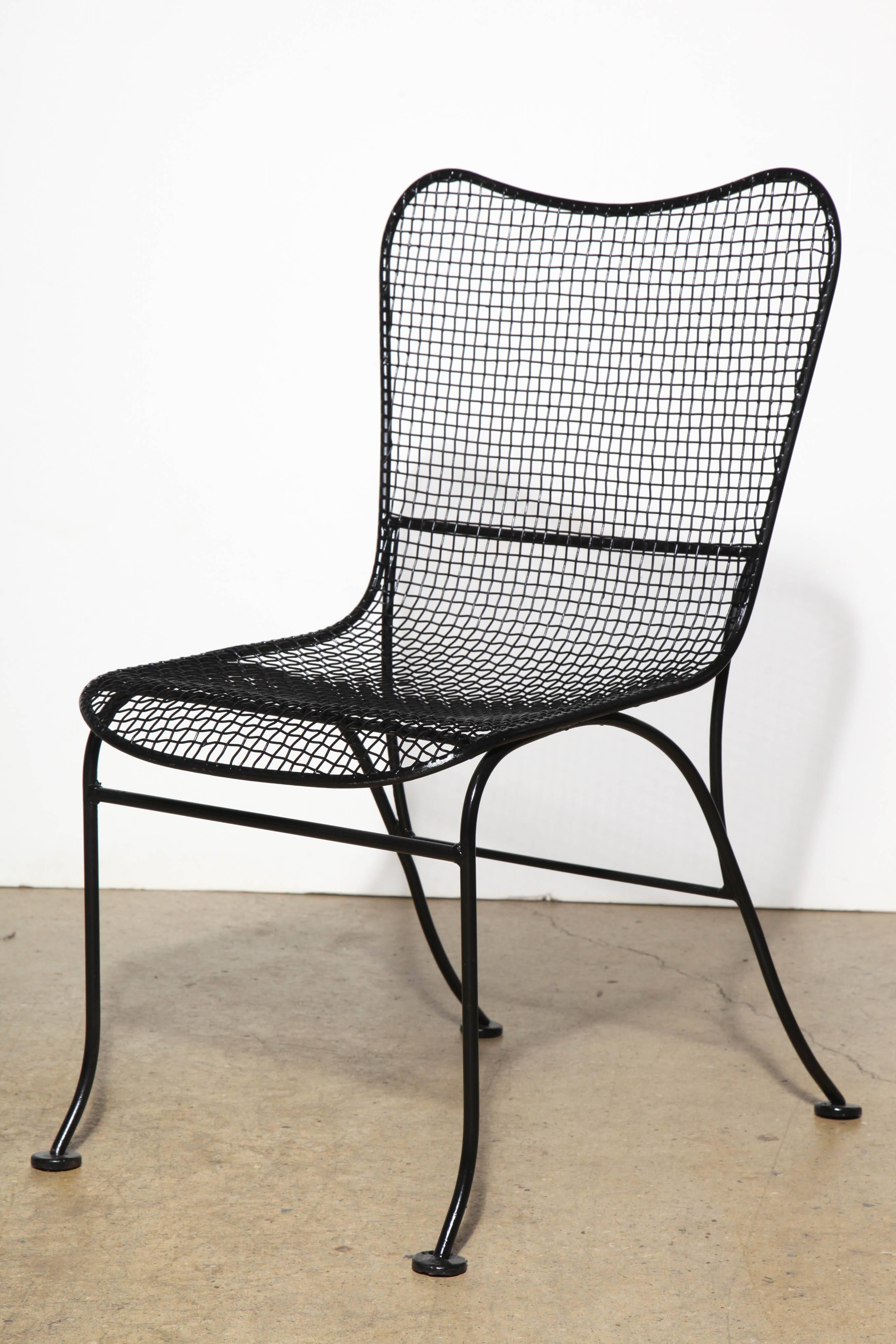 Four scarce, comfortable and elegant 1950s Russell Woodard wire mesh garden chairs. Black Wrought framework and legs. Ergonomic wire mesh seat and bowed back