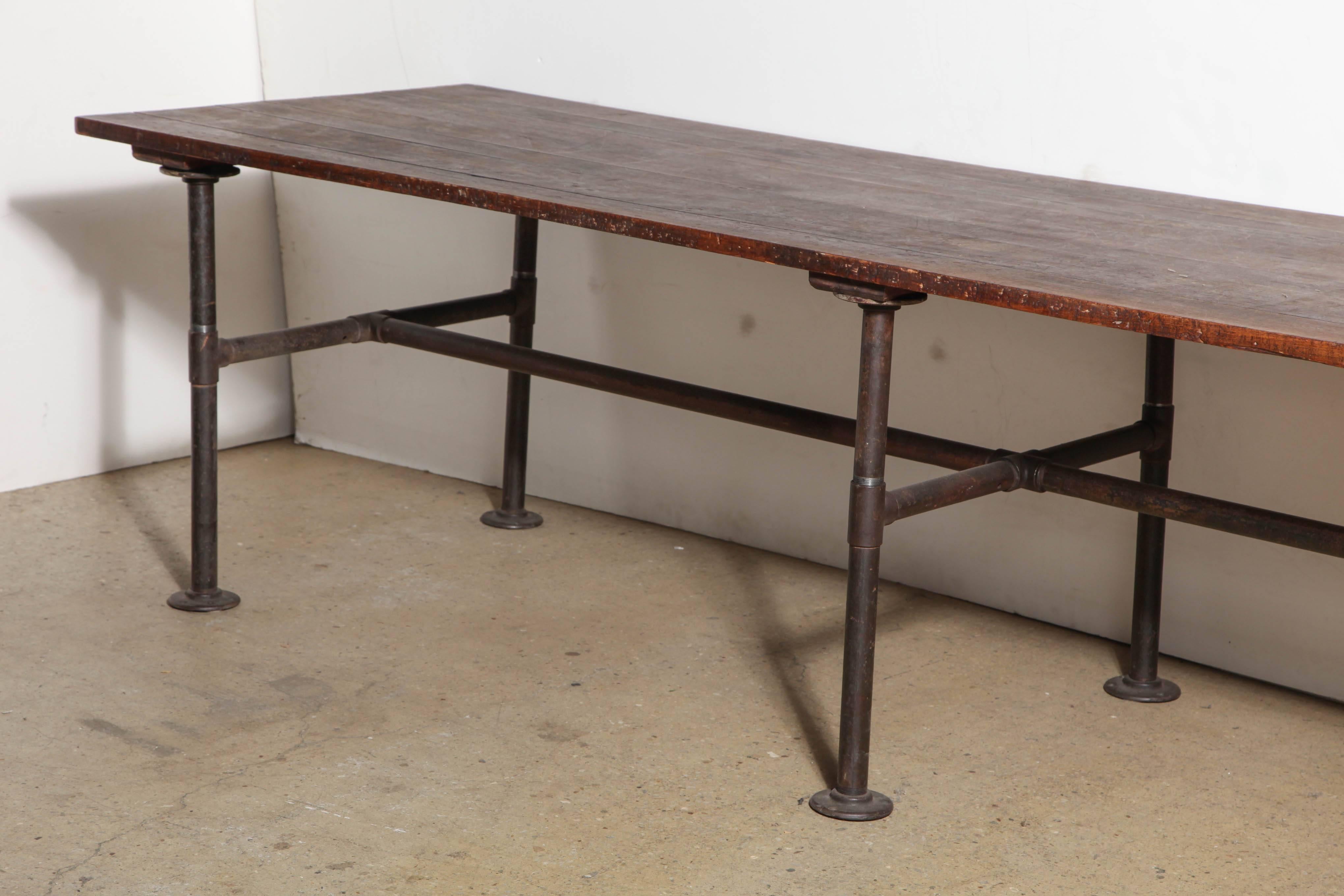 Industrial Late 19th Century Extra Long 10' Foot Fabric Cutting Table. Featuring 1.18H Dark Black Walnut (120 inch length) Top, six Iron pipe legs and open framework support.  Height can be adjusted lower by 3/4 inch. Nice original old finish top.