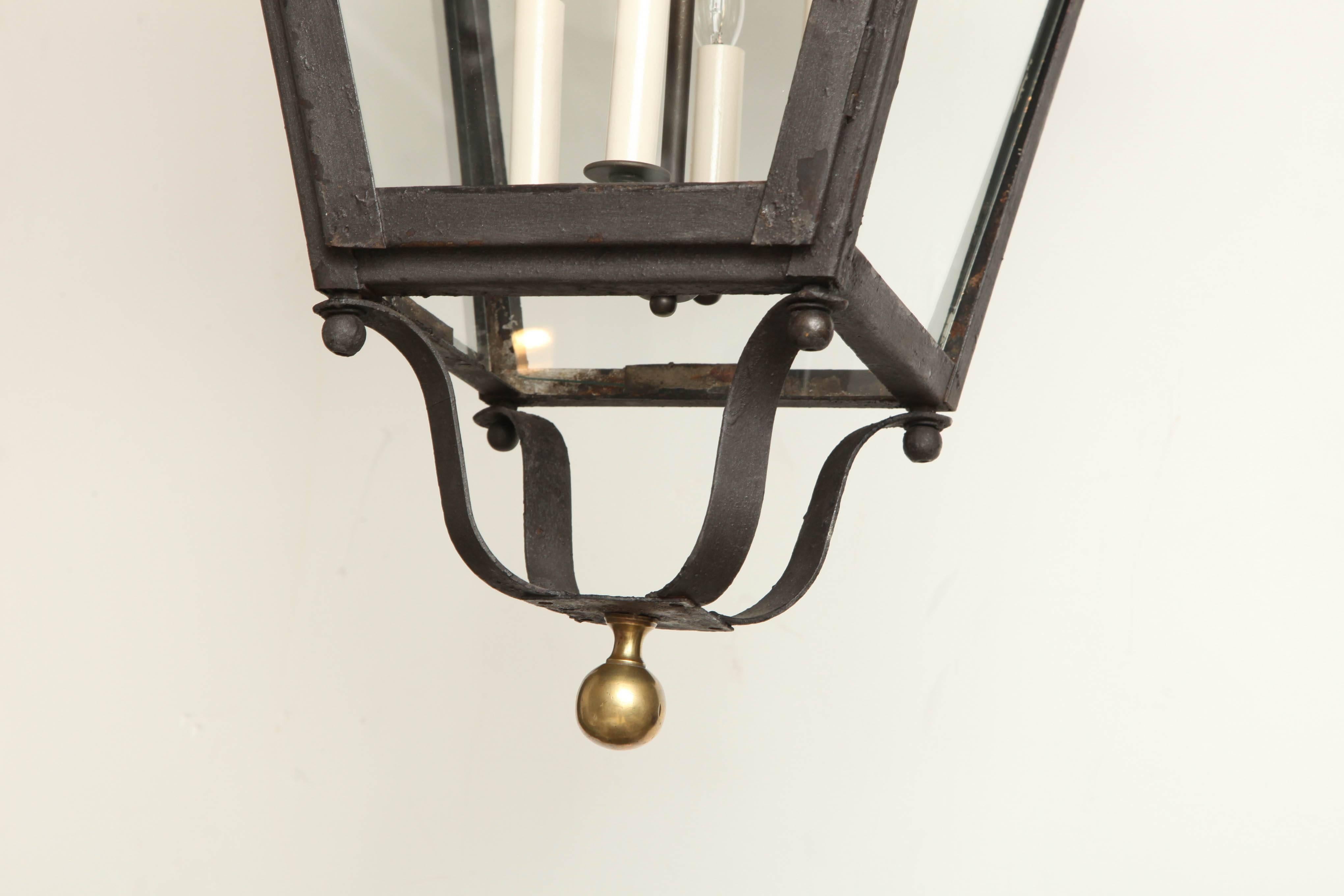 A French, 19th century black iron and glass square, tapering lantern with brass ball finial.
 