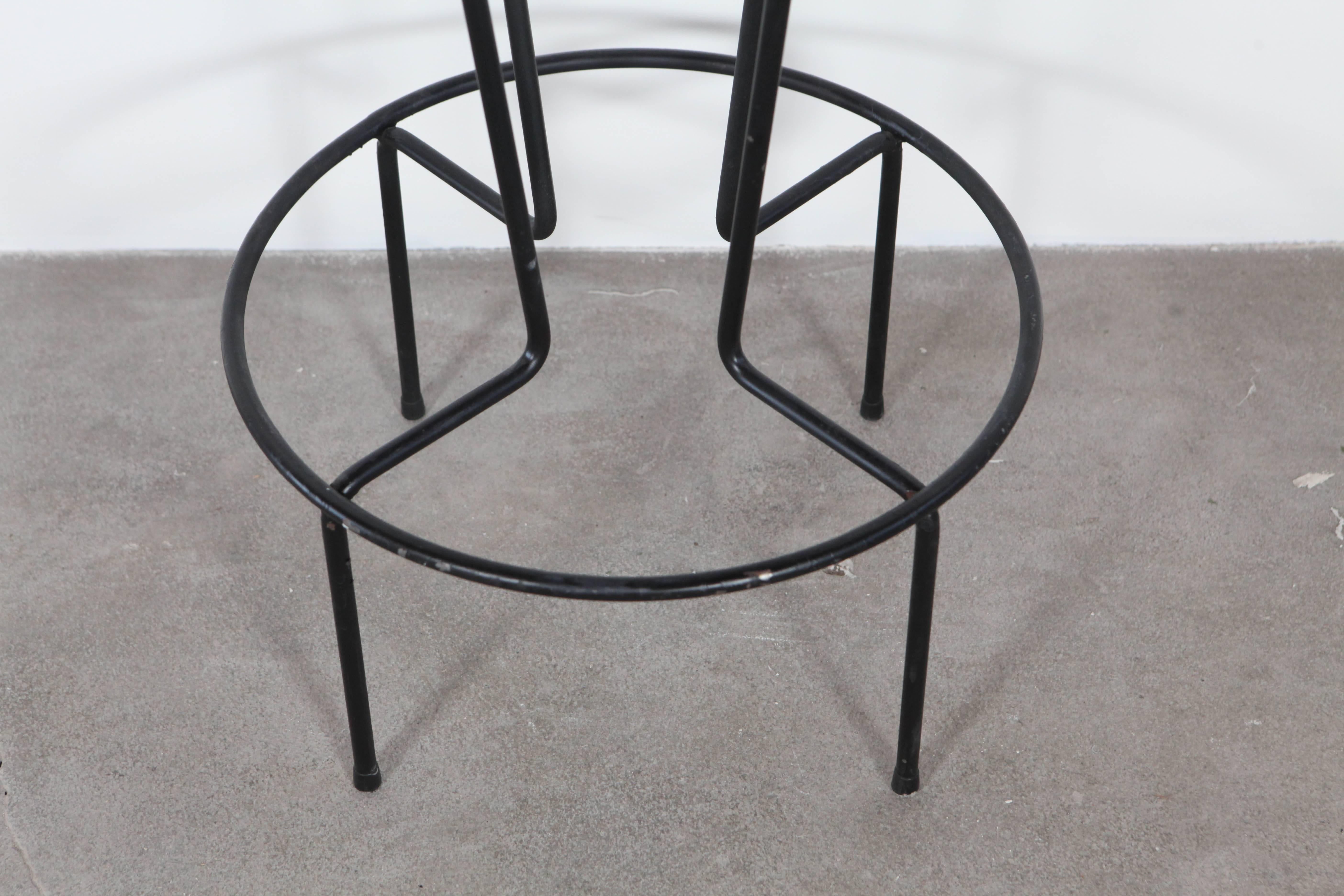 Four iron barstools with grey wool seat.