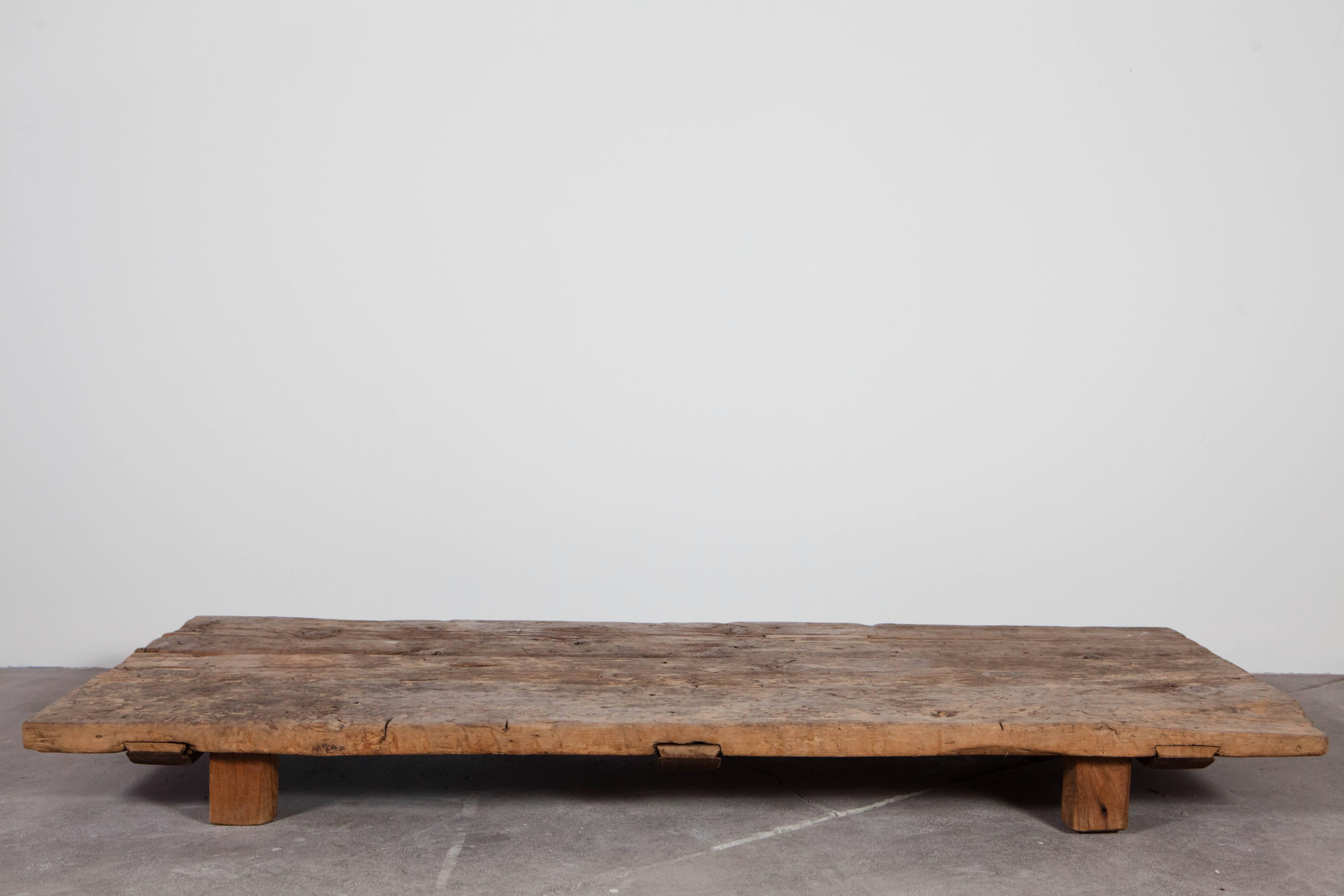 Exceptional low coffee table in distressed and marred planks of wood.