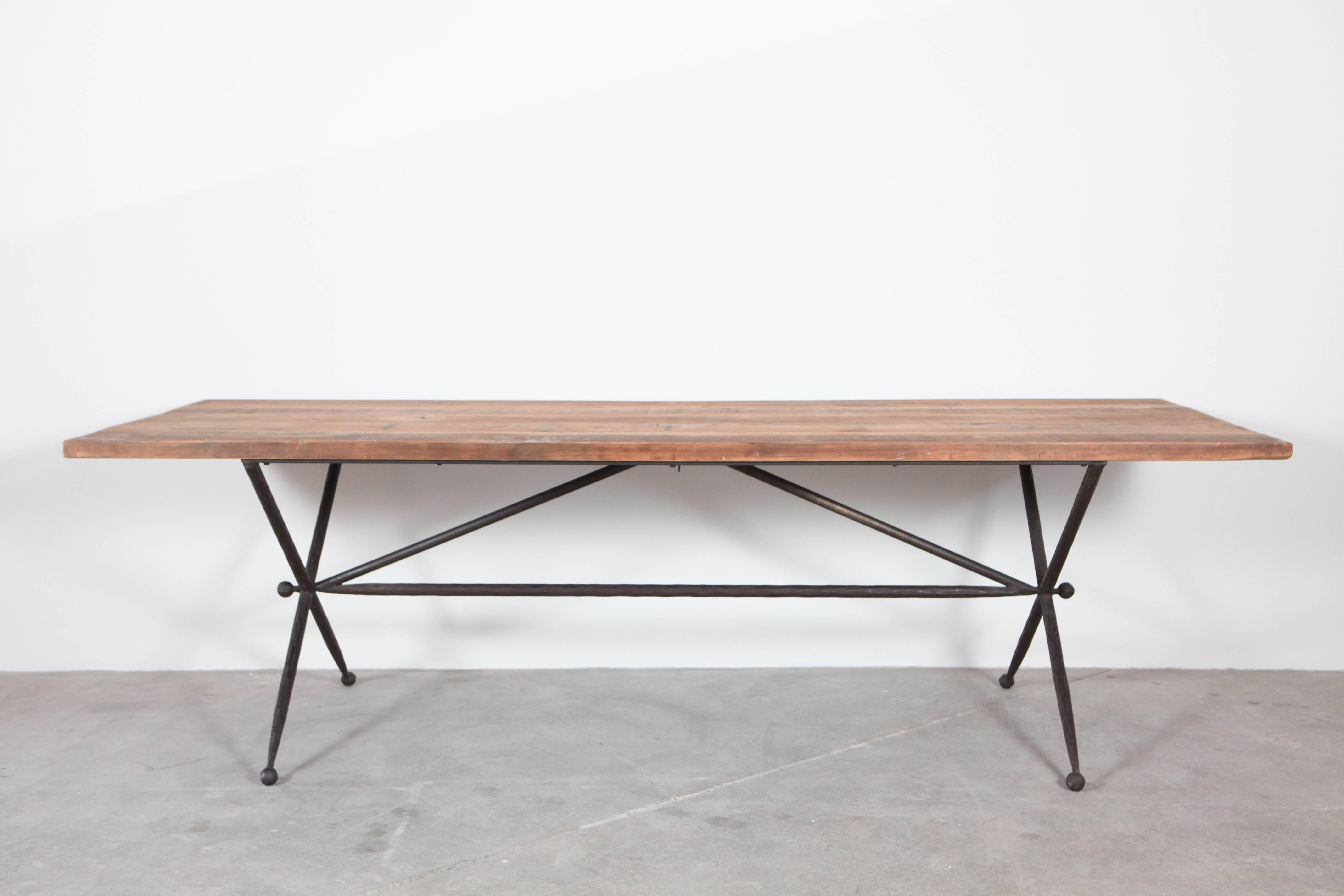 Long dining table with geometric base and rustic top.