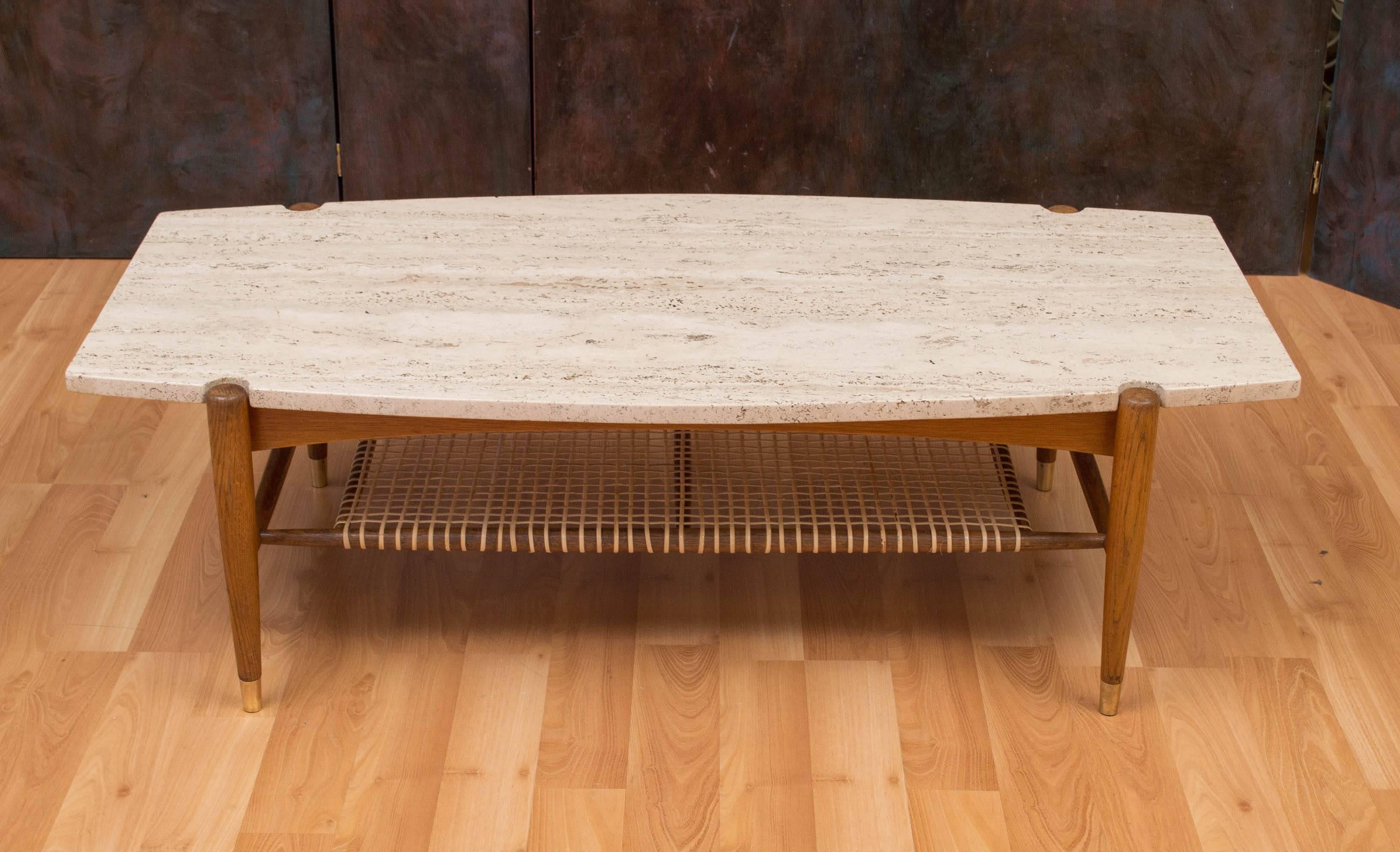 Dux of Sweden coffee table, it's been attributed to Bruno Mathsson. Oak base with Brass caps on it's leg ends, with a cane shelf underneath, holding up an oval shape travertine top, travertine is stamped 