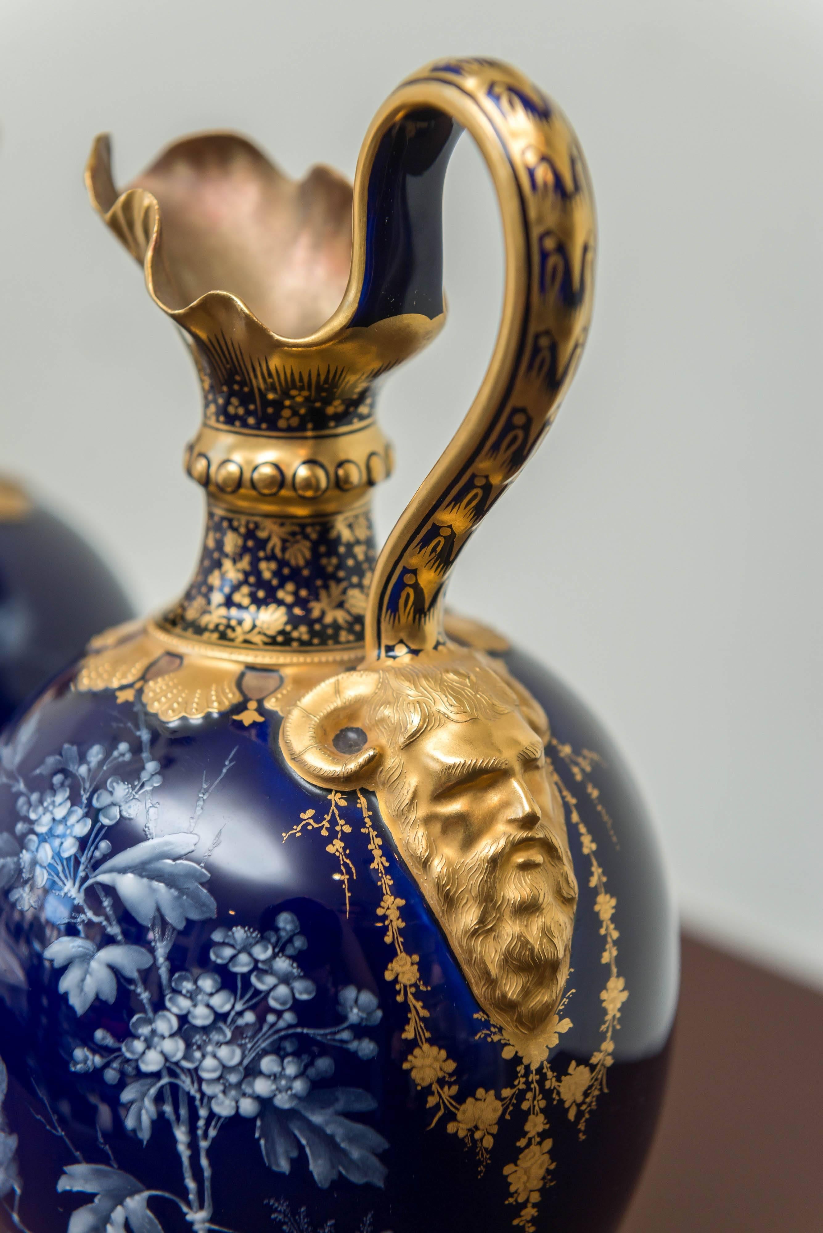 Pair of Royal Crown Derby porcelain cobalt-blue ground ewers. Date cypher for 1893, iron-red crowned monogram mark, signed Le Roy (Desire Le Roy). Baluster form loop handle with satyr-mask spout. Finely painted with sparrows eyeing insects as they