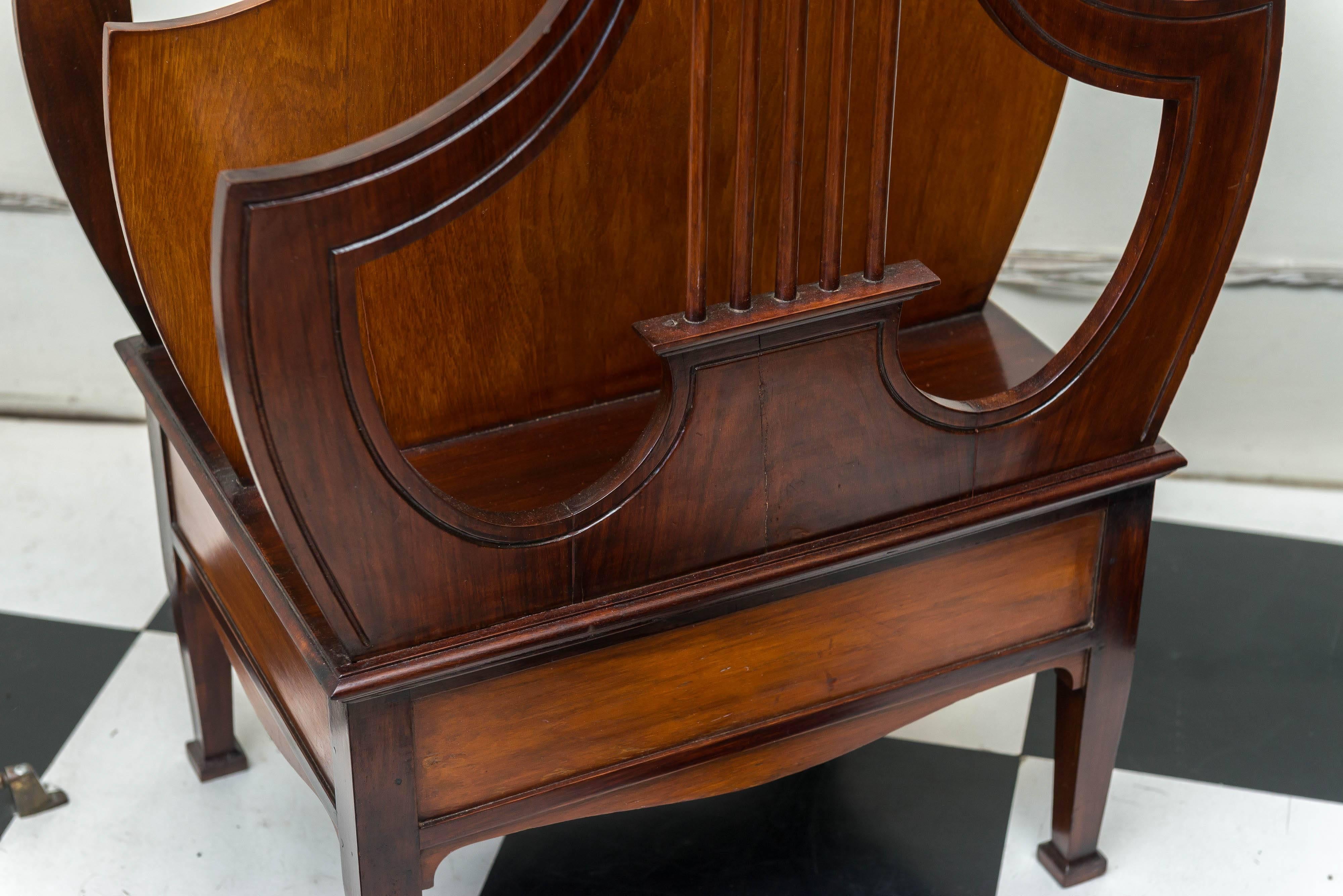 Late 19th century English rosewood lyre form music/folio stand. Two large compartments, fixed base and a very strong build. Compartments are 22.25 inches wide x 6.25 deep x 18 inches height. Incised carved details above a panel and frame base with
