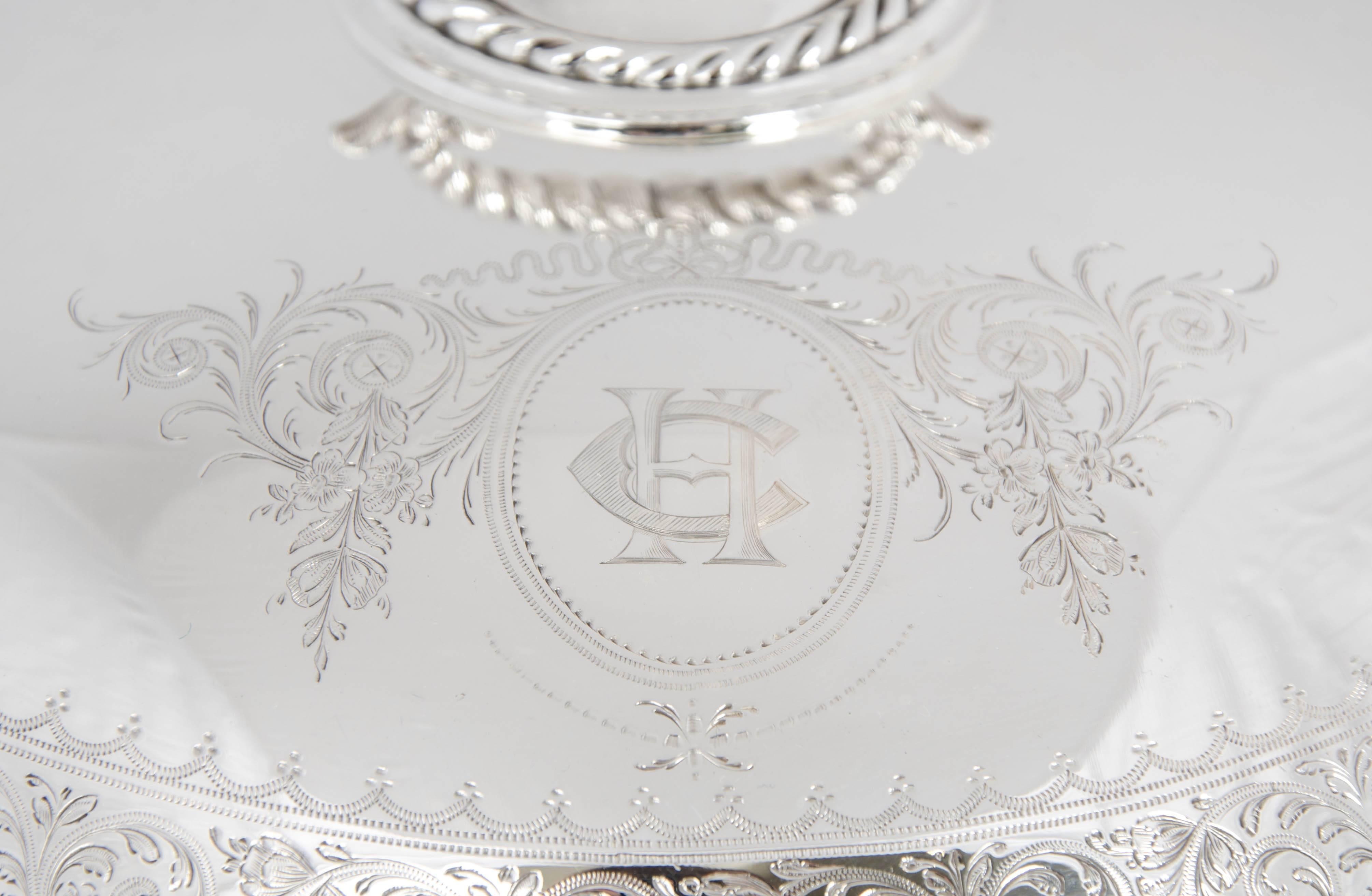 Silver plate serving dish with removable partition. It has a rope trim to the dish with fine engraving around the edge of the lid.