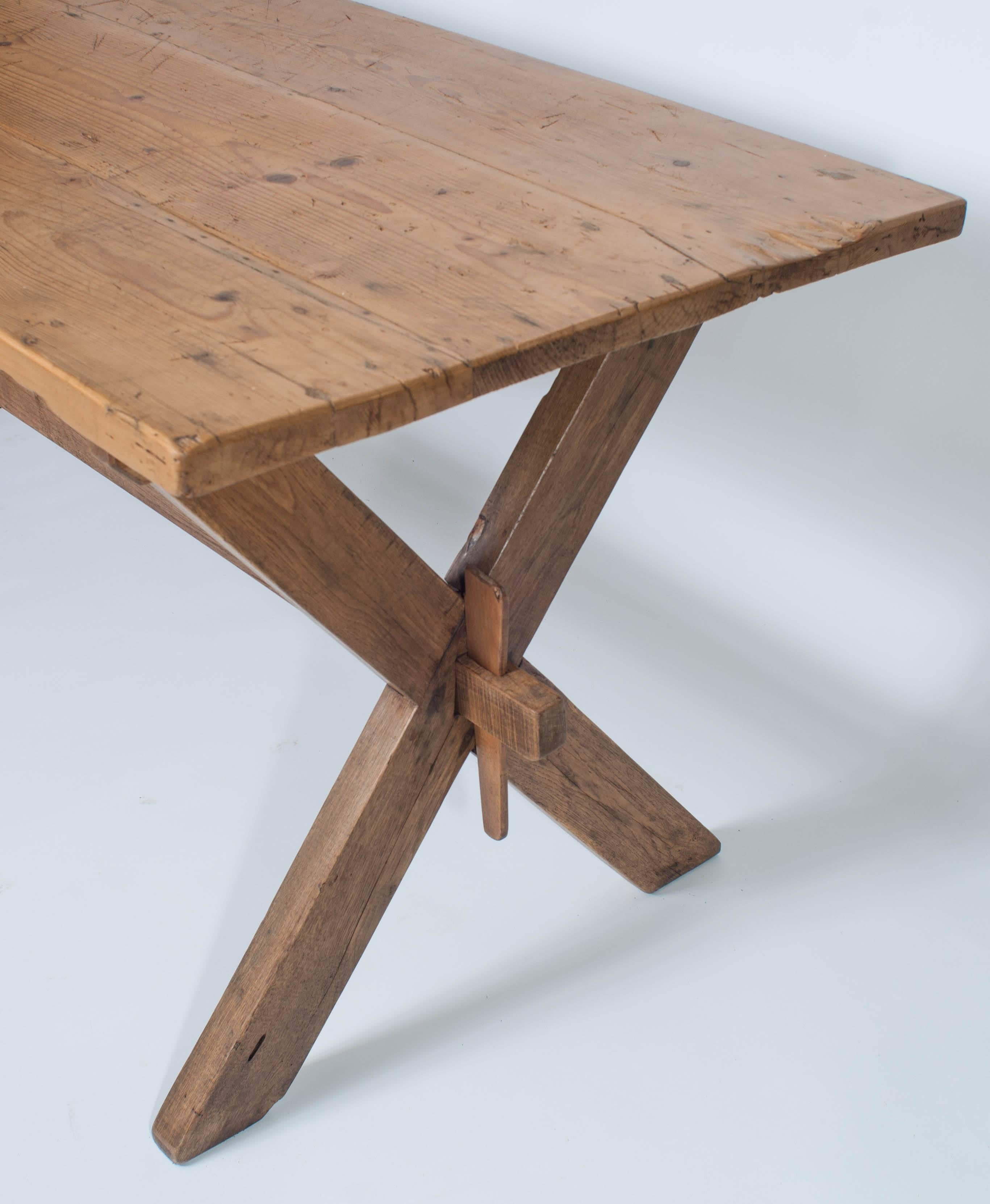 This beautiful table features a sawbucks style trestle base with central stretcher and original wooden keys in oak.  The three board top is in pine, almost 1.5