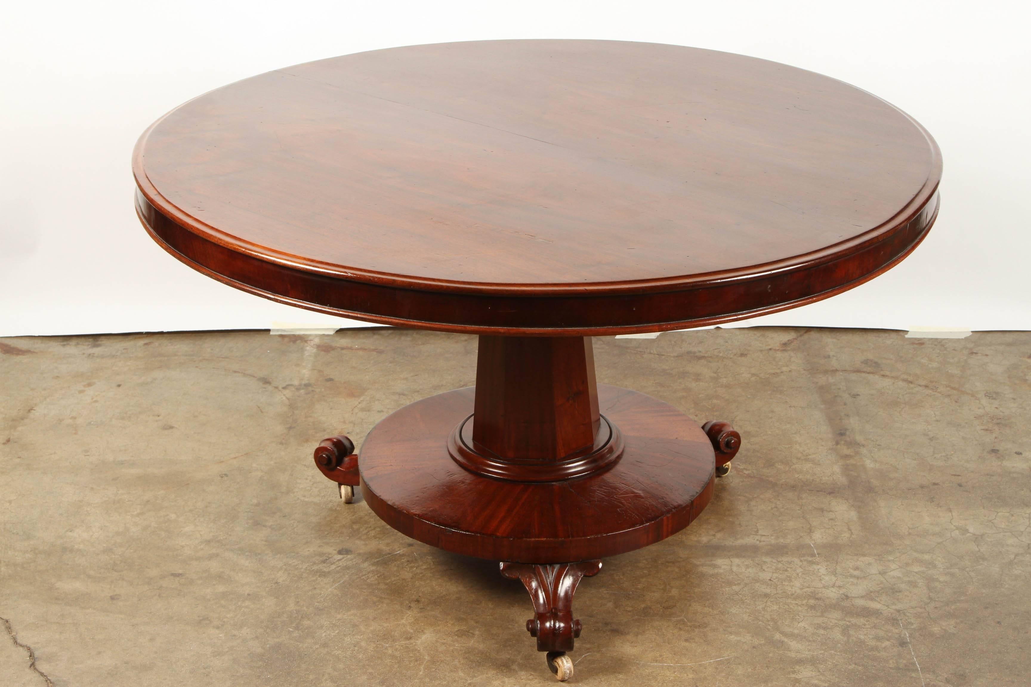 Beautiful Mahogany tilt top pedestal table from the Regency period. The table has an 8 sided pedestal and a round skirt, on 3 scroll feet. Each of the scroll feet is fitted with wheels for rolling.   The table top tilts to one side for easier